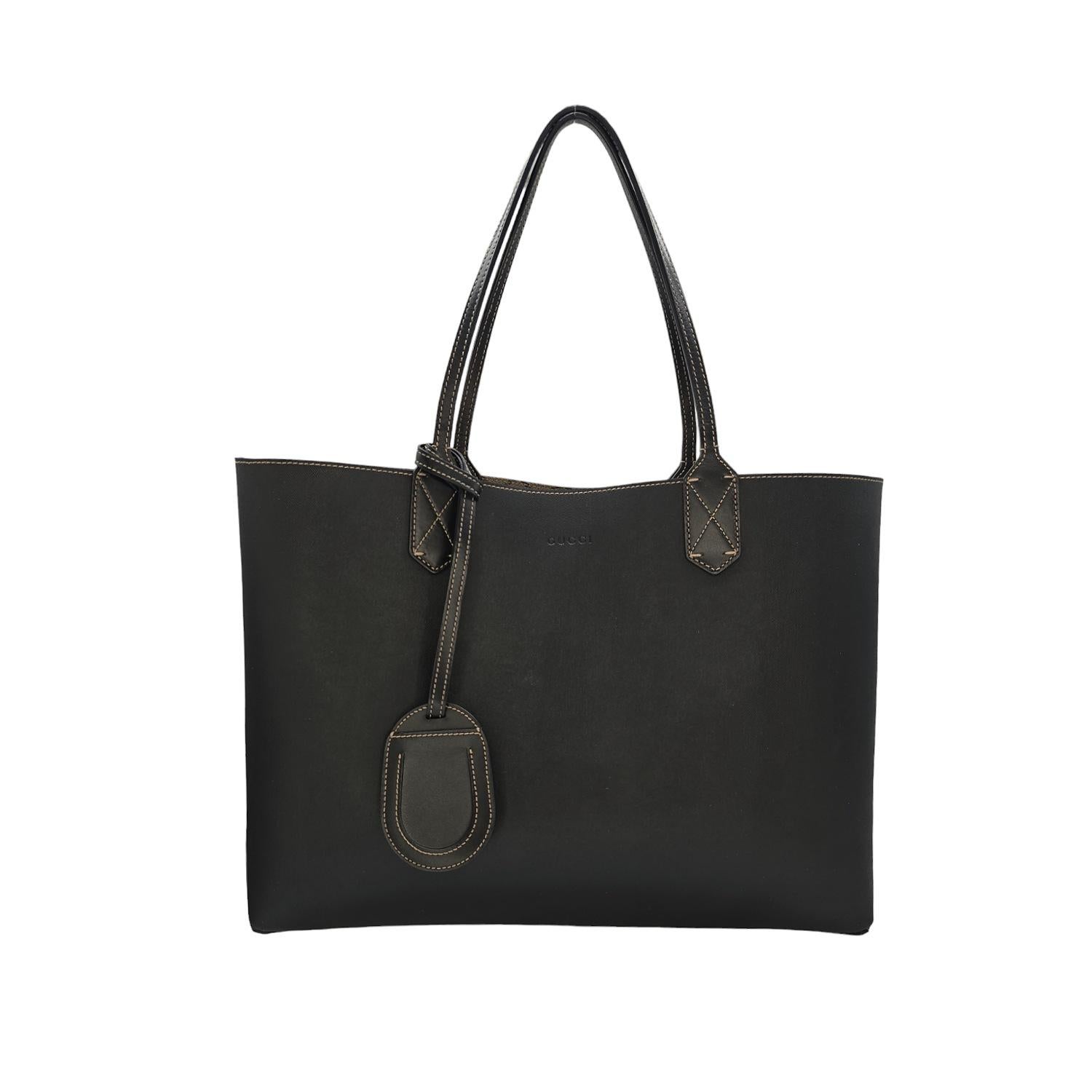 This stylish tote is crafted of classic Gucci GG monogram coated canvas, with a reversible coated black canvas lining, and black leather top handles. This versatile tote is perfect for all of your daily necessities.

Designer: Gucci
Material: GG