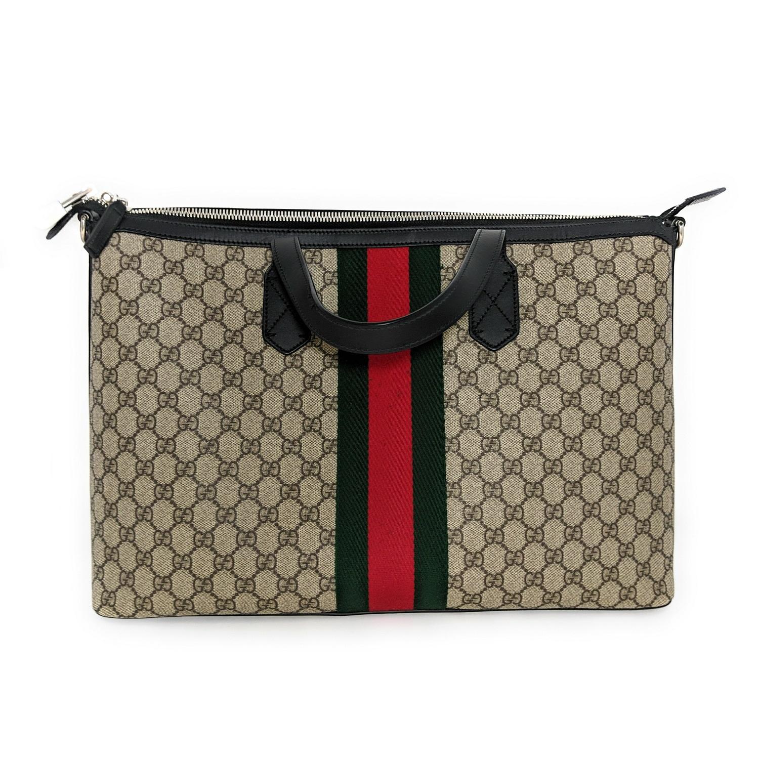 This large stylish tote is crafted of Gucci GG monogram canvas detailed with a black complimentary trim along the top crest and corner reinforcements. The bag features a wide 3 inch web stripe along the mid-center body of the bag with black rolled