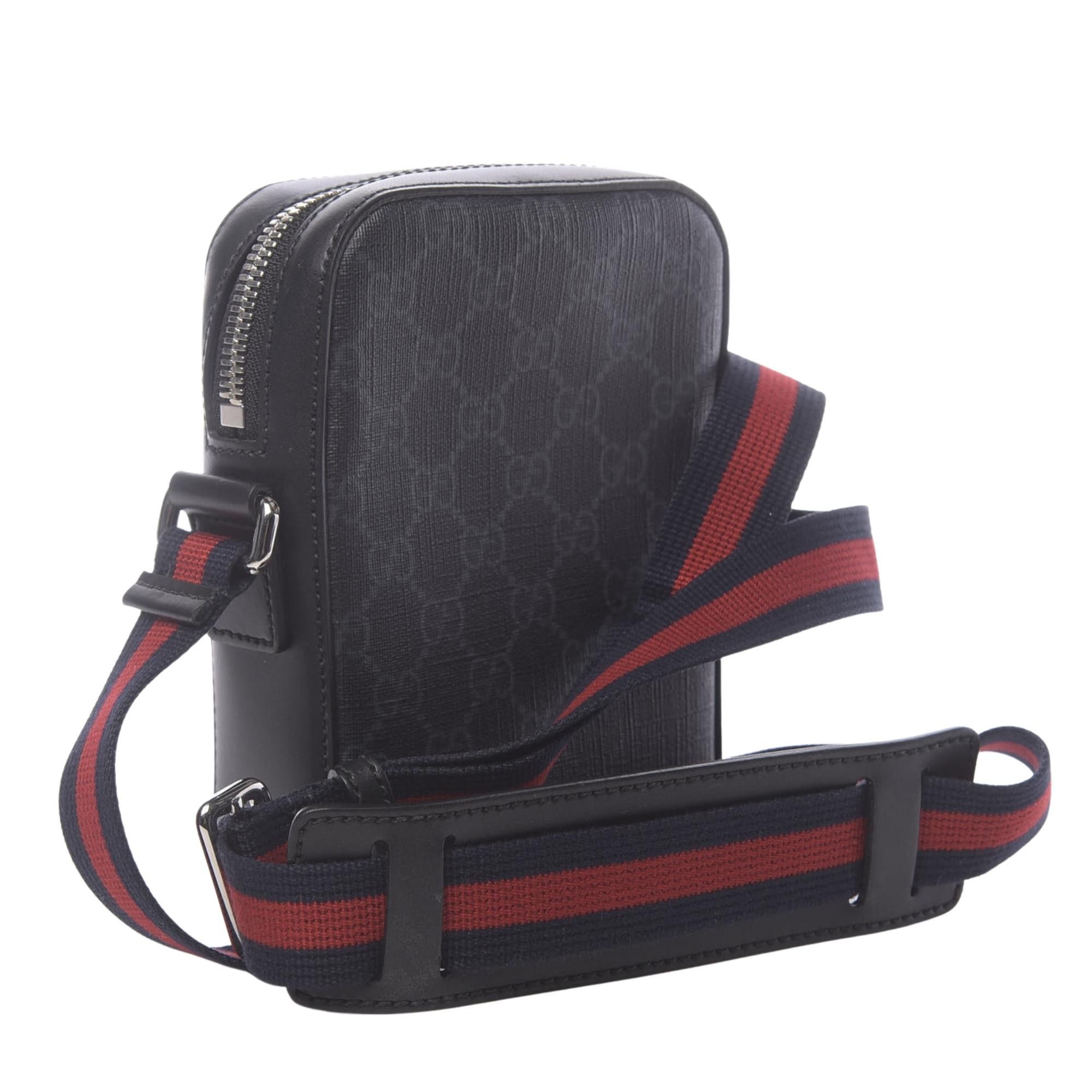 This contemporary looking messenger bag is made of black Gucci GG monogram coated canvas. The bag features a black/grey GG Supreme canvas, black leather trim, blue and red Web strap, palladium-toned hardware, front zipper pocket and cotton linen