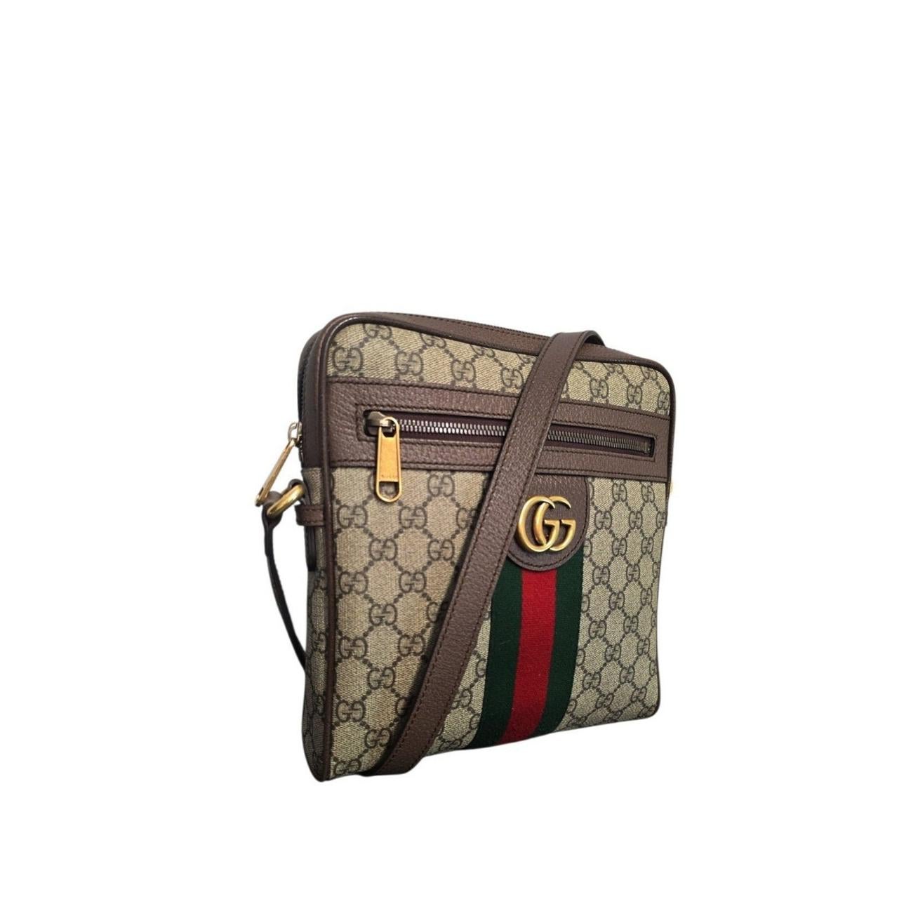Le sac à main GG Supreme Monogram Web Small Ophidia de Gucci est réalisé en toile enduite monogrammée, avec des finitions en cuir marron et la bande web classique rouge et verte au centre. Le sac est doté d'une bandoulière réglable en cuir marron,