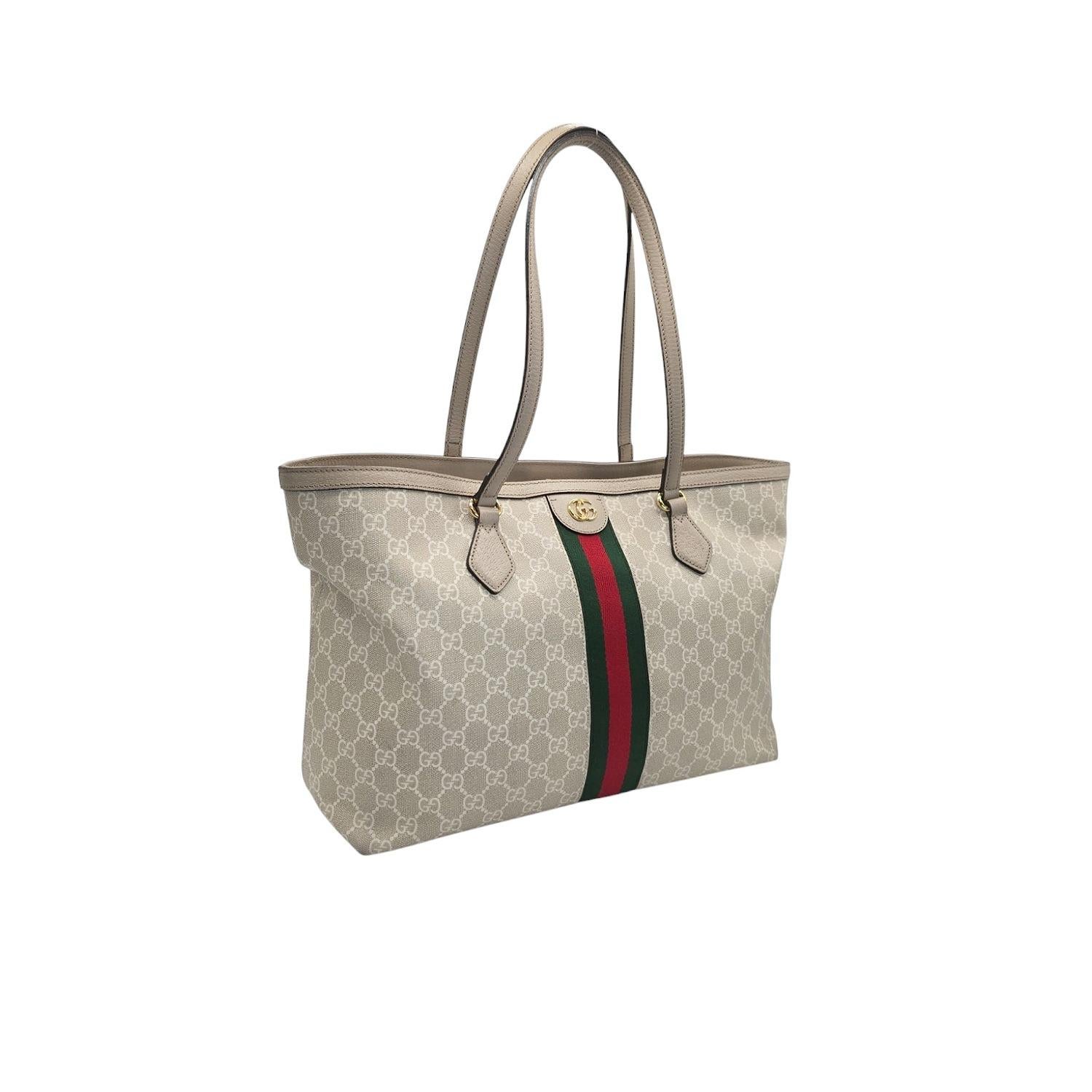 Indulge in luxury with the Gucci GG Supreme Medium Ophidia Tote. Crafted in Italy with the finest materials, this tote features the iconic GG Supreme coated canvas, accented with leather trimming and gold-tone hardware. The spacious interior,