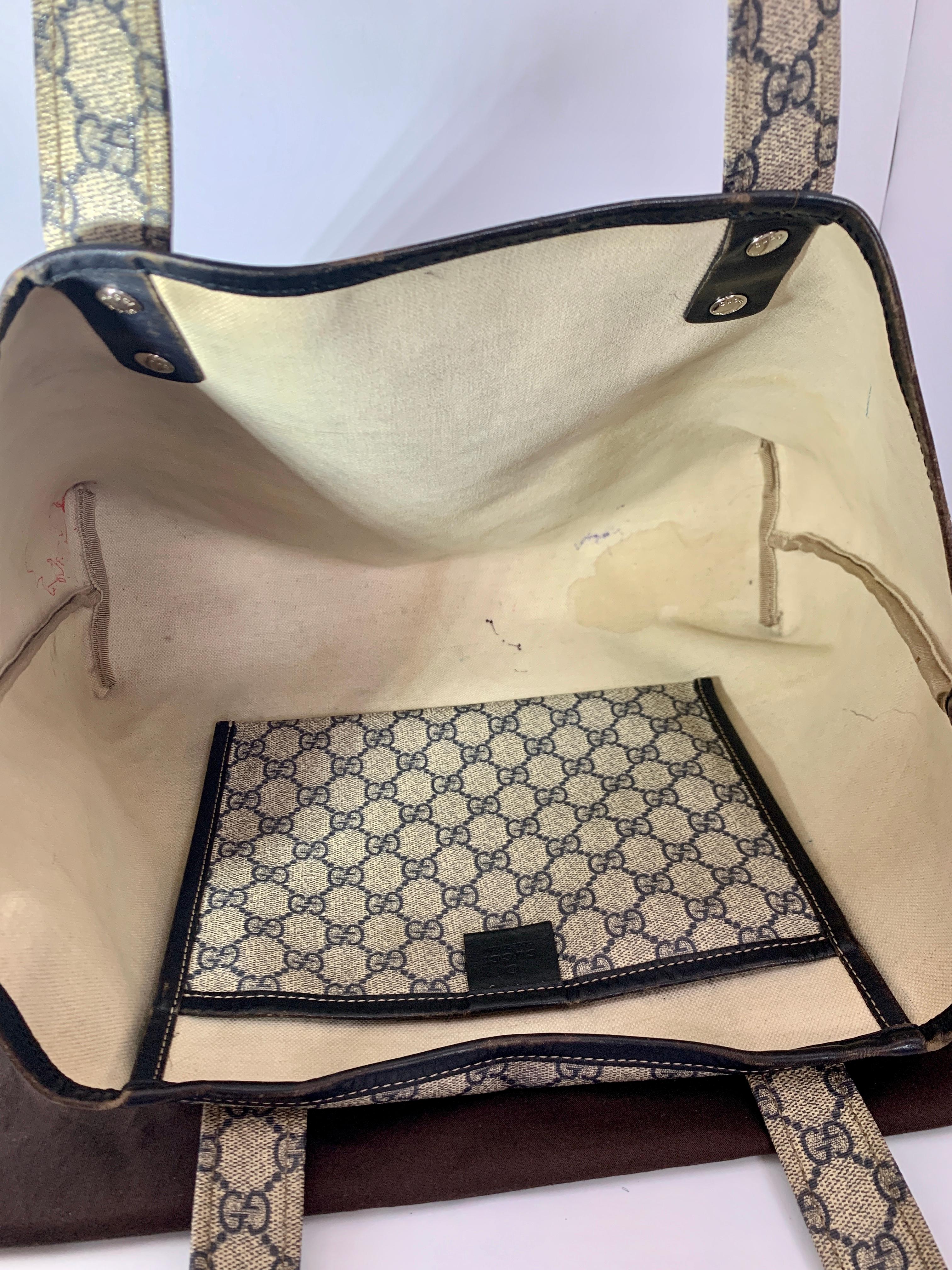 This is an authentic GUCCI Monogram Large Original Tote bag . This chic tote is crafted of traditional navy blue Gucci GG monogram PVC leather. . The top  opens to a spacious natural fabric interior with one large  hanging pocket .  This is an