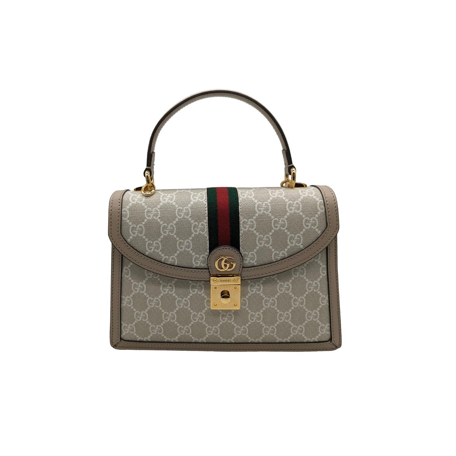 This Gucci top handle satchel is beautifully crafted of white on beige Gucci GG Supreme coated canvas. The bag features an adjustable beige leather shoulder strap with aged gold hardware, a green and red web stripe detail down the center, and a