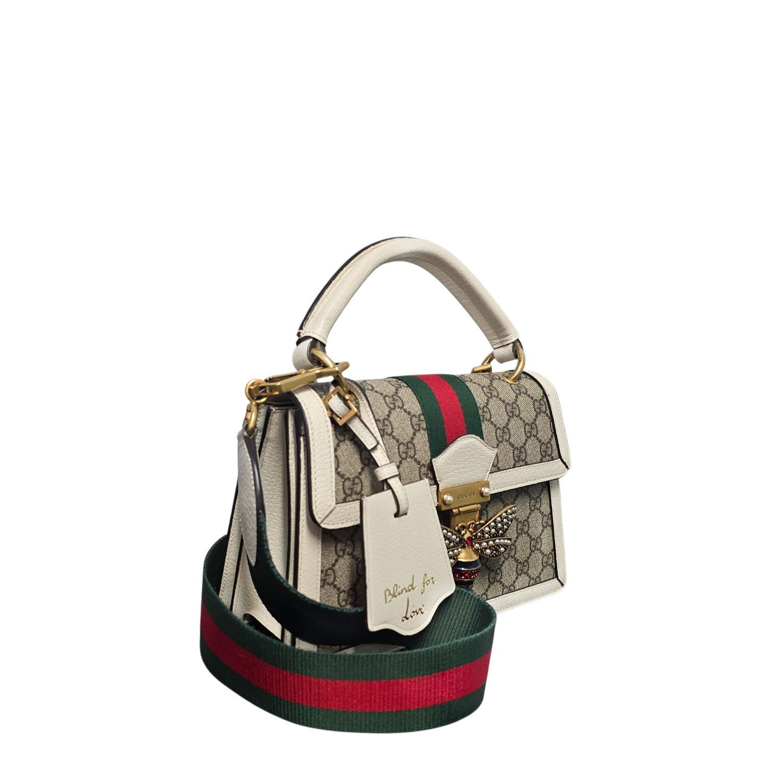 Ce sac à main Gucci GG Supreme Monogram Small Queen Margaret Top Handle Bag est réalisé en toile enduite Gucci GG supreme monogram, avec des finitions en cuir de veau blanc. Le sac est doté d'une poignée supérieure en cuir roulé, d'une bandoulière