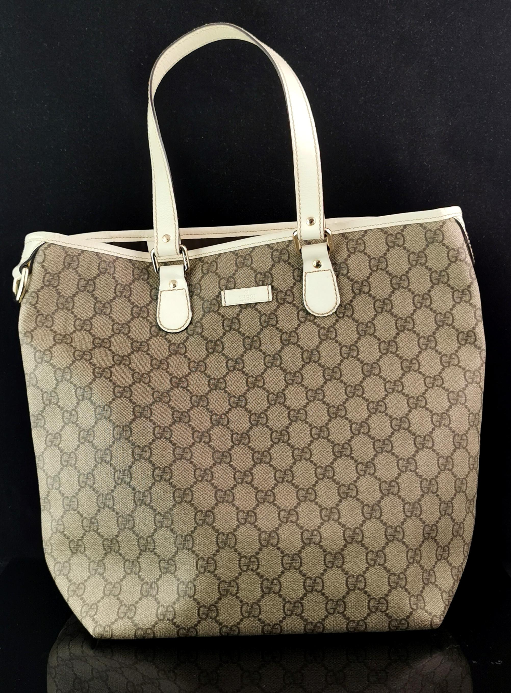 A stylish vintage Gucci GG supreme tote bag.

A tall tote with all over GG monogram to the coated canvas fabric, it is a beige / brown tone with cream leather handles and tags.

The bag is open top with a branded tag to both the outside and inside