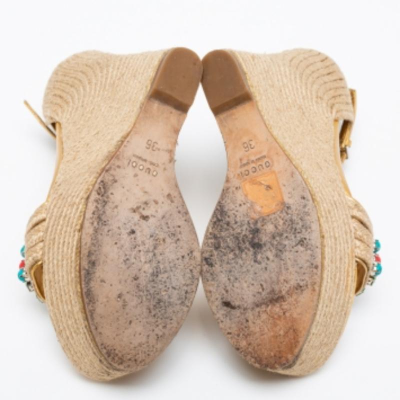 These wedges by Gucci are to complement summer soirées. They are made from jute as well as gold leather and added with open toes, embellished uppers, ankle strap closure, and wedge heels.