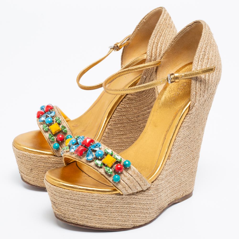 These wedges by Gucci are to complement summer soirées. They are made from jute as well as gold leather and added with open toes, embellished uppers, ankle strap closure, and wedge heels.