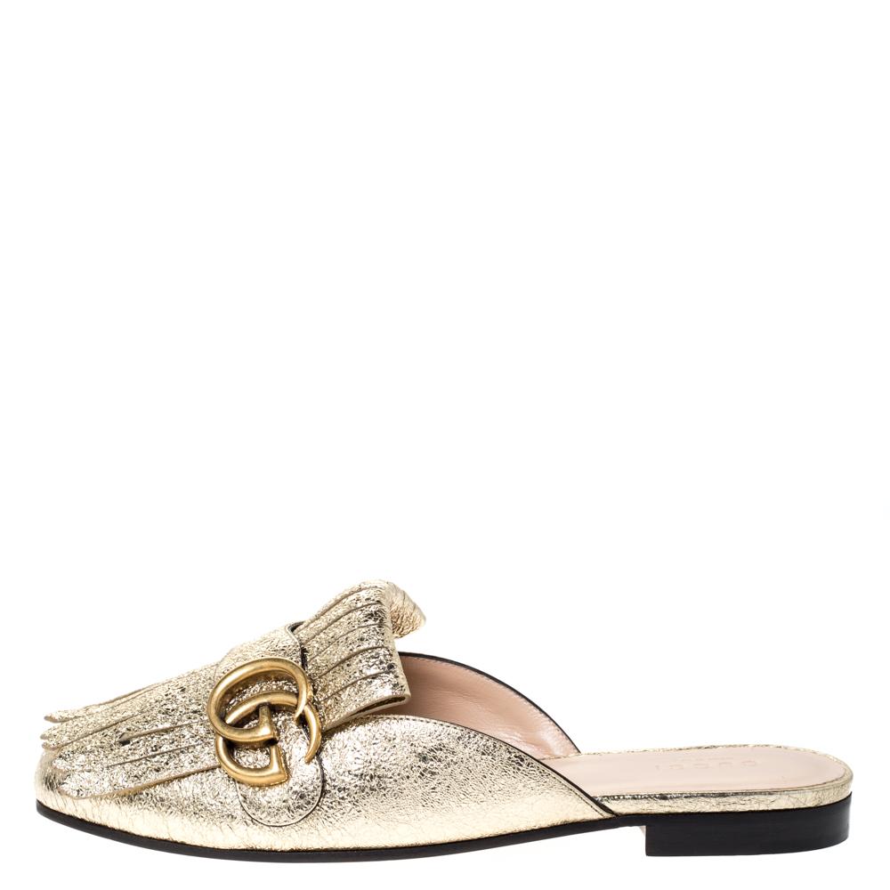 This pair of mules by Gucci is a buy to wear and treasure. They've been crafted from foil leather and styled with folded fringes with the brand's signature GG on the uppers. Covered toes and durable soles complete the pair.

Includes:Original