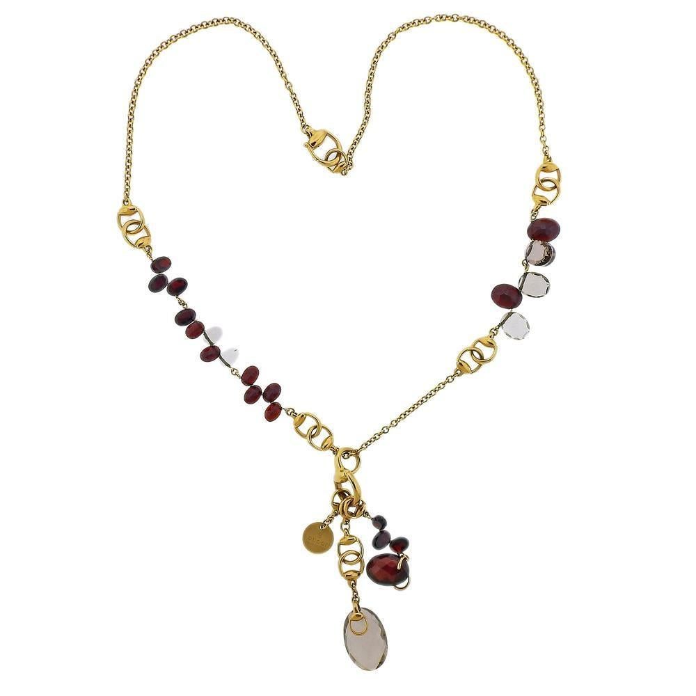 18k yellow gold gemstone pendant necklace by Gucci, featuring faceted garnets and smokey quartz. Necklace is 19