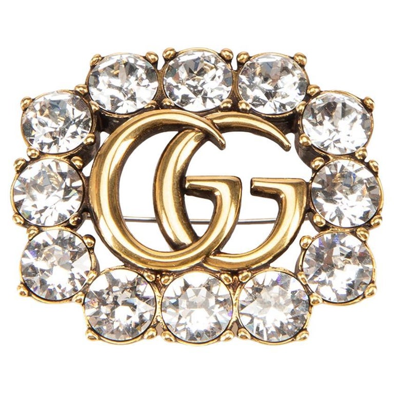 Gucci Broche en or ornée de cristaux GG sur 1stDibs
