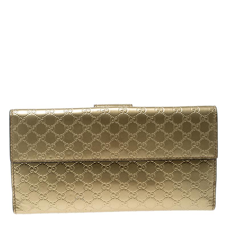Crafted from Guccissima patent leather, this gorgeous continental wallet from Gucci carries a lovely gold exterior. The flap is accented with a label-engraved heart motif that opens to a leather interior equipped with multiple slots and compartments