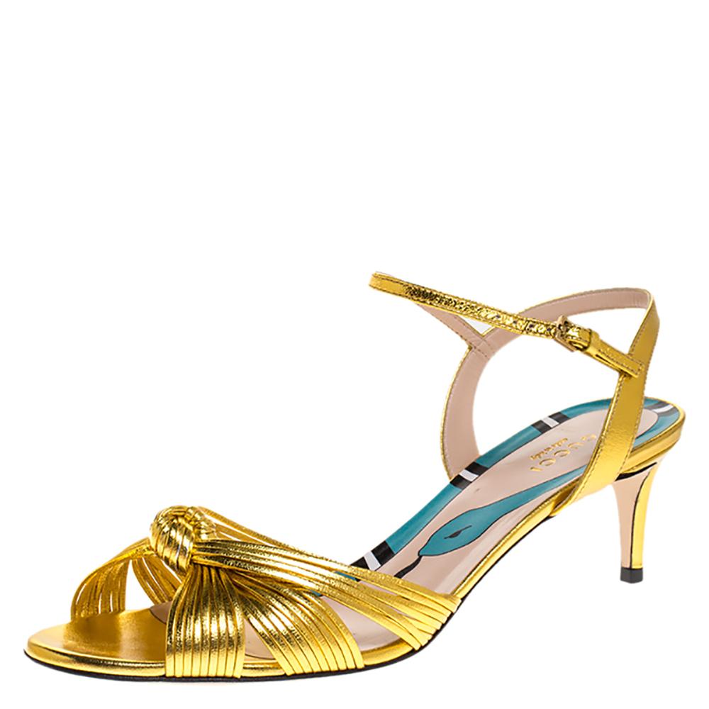 Strut in style and make the streets your fashion runway with these spectacular gold sandals from Gucci. The lovely sandals are crafted from leather and feature an open-toe style. They flaunt knotted vamps, ankle straps with gold-tone buckles,