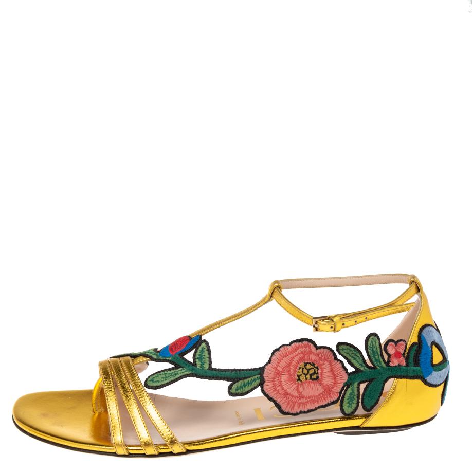 Wear luxury with a touch of high fashion by choosing these gold-hued flats from Gucci. They are crafted from leather in an open-toe T-strap silhouette and detailed with floral embroidered patches that extend from the vamps to the counters. They are