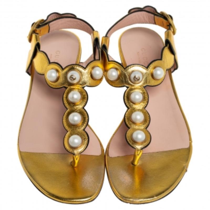 Perfect for channeling an air of elegance, these sandals from Gucci are worth investing in. The gold sandals are crafted from leather and feature a T-strap design with pearls, buckled ankle straps, comfortable leather-lined insoles, and gold-tone