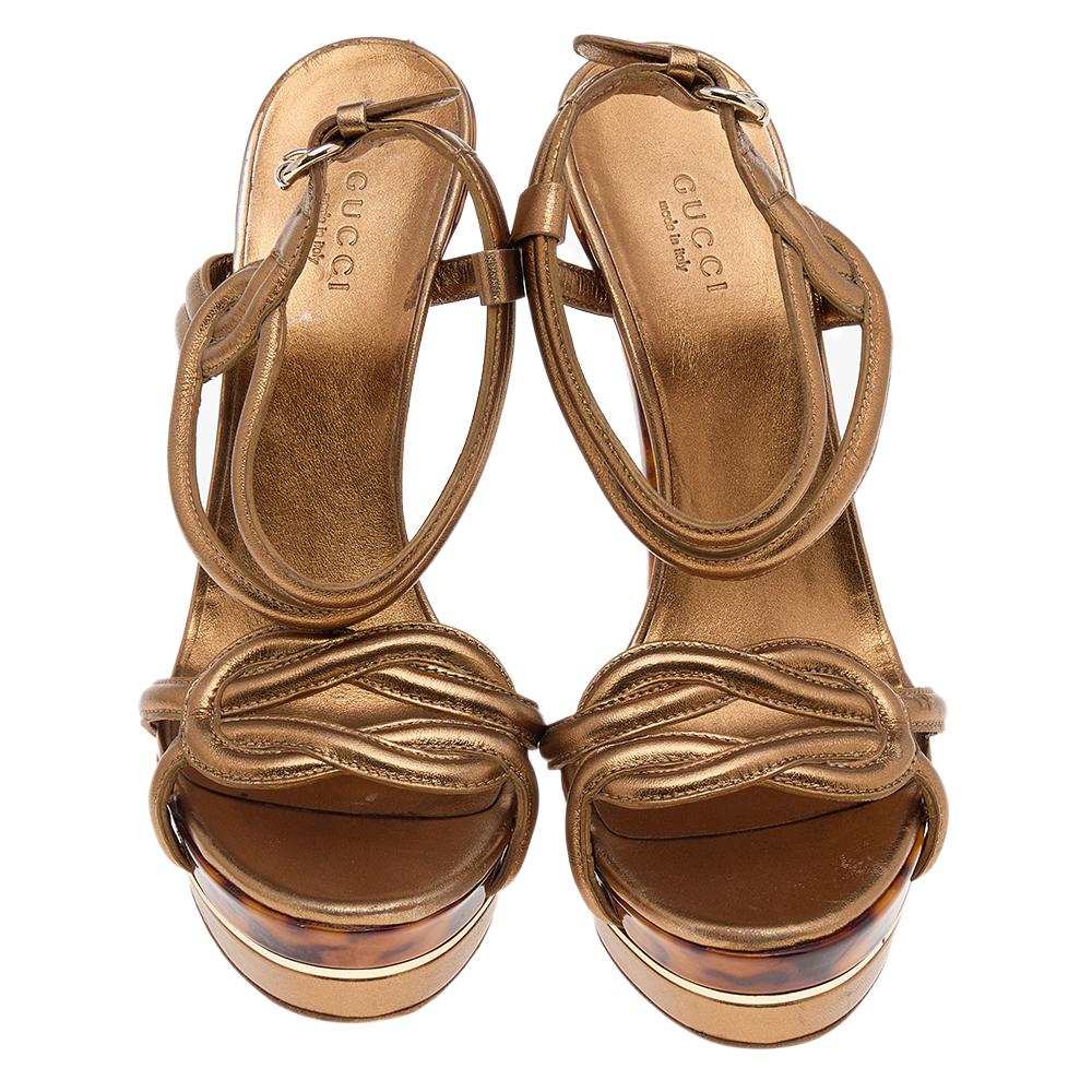 Straps in gold leather have been used to form this gorgeous pair by Gucci. The twist design, open toes, and buckled ankle straps are added to frame your feet in an alluring way. 15 cm heels finish the luxe pair.

