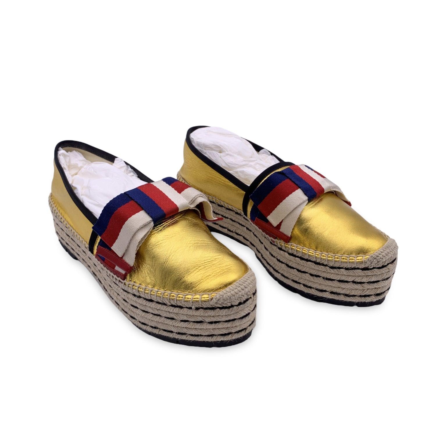 Gucci gold metal leather Espadrille shoes. These shoes are crafted from leather and feature round toes and a white, red and blue Web bow detail across the vamps. Platform height: 2 inches - 5.1 cm. Size 41 Details MATERIAL: Leather COLOR: Gold