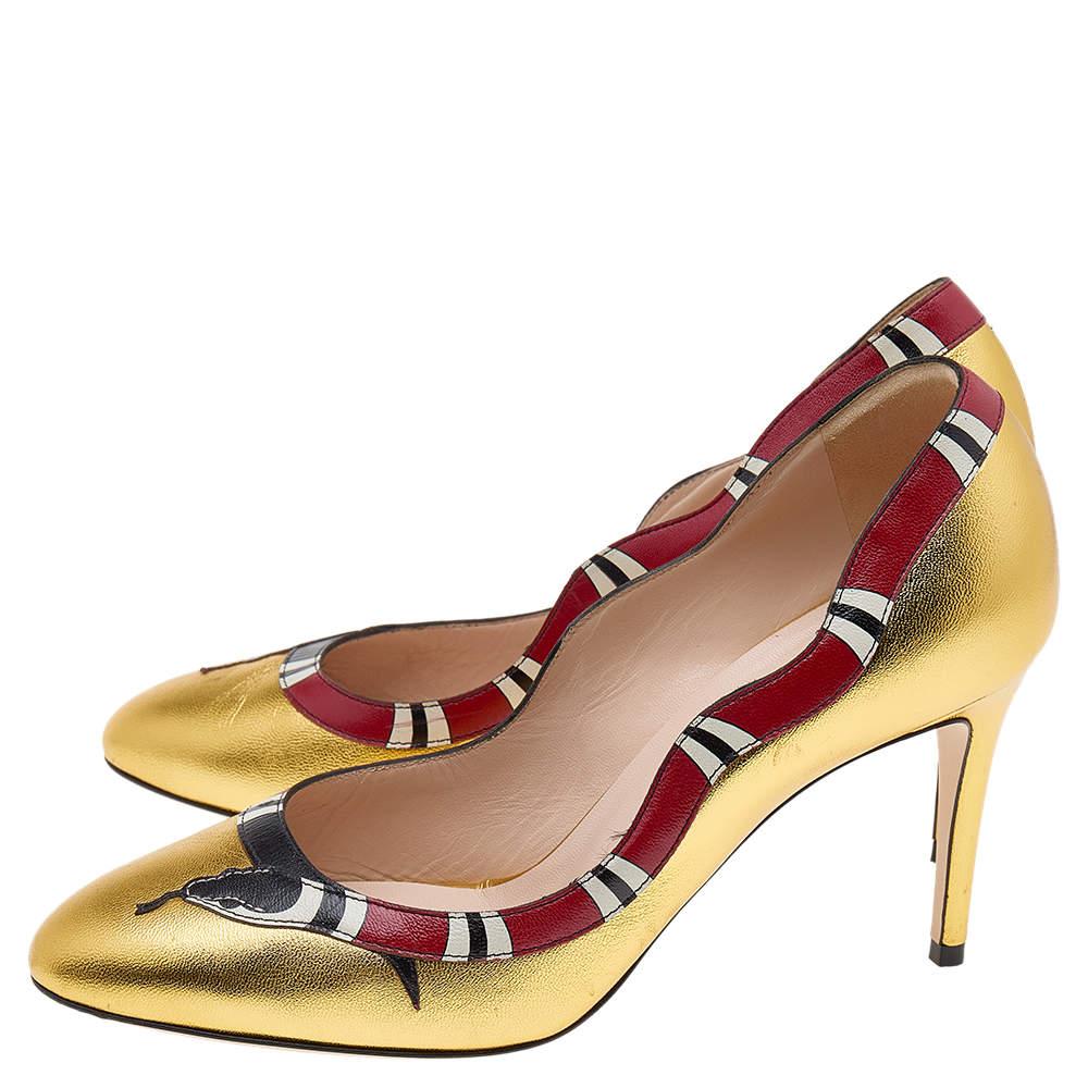 These Gucci pumps have clear potential to uplift your spirits! These pumps are designed with gold leather and showcase a snake pattern on the scalloped topline for some extra character. They come with almond toes and high heels. The insoles are