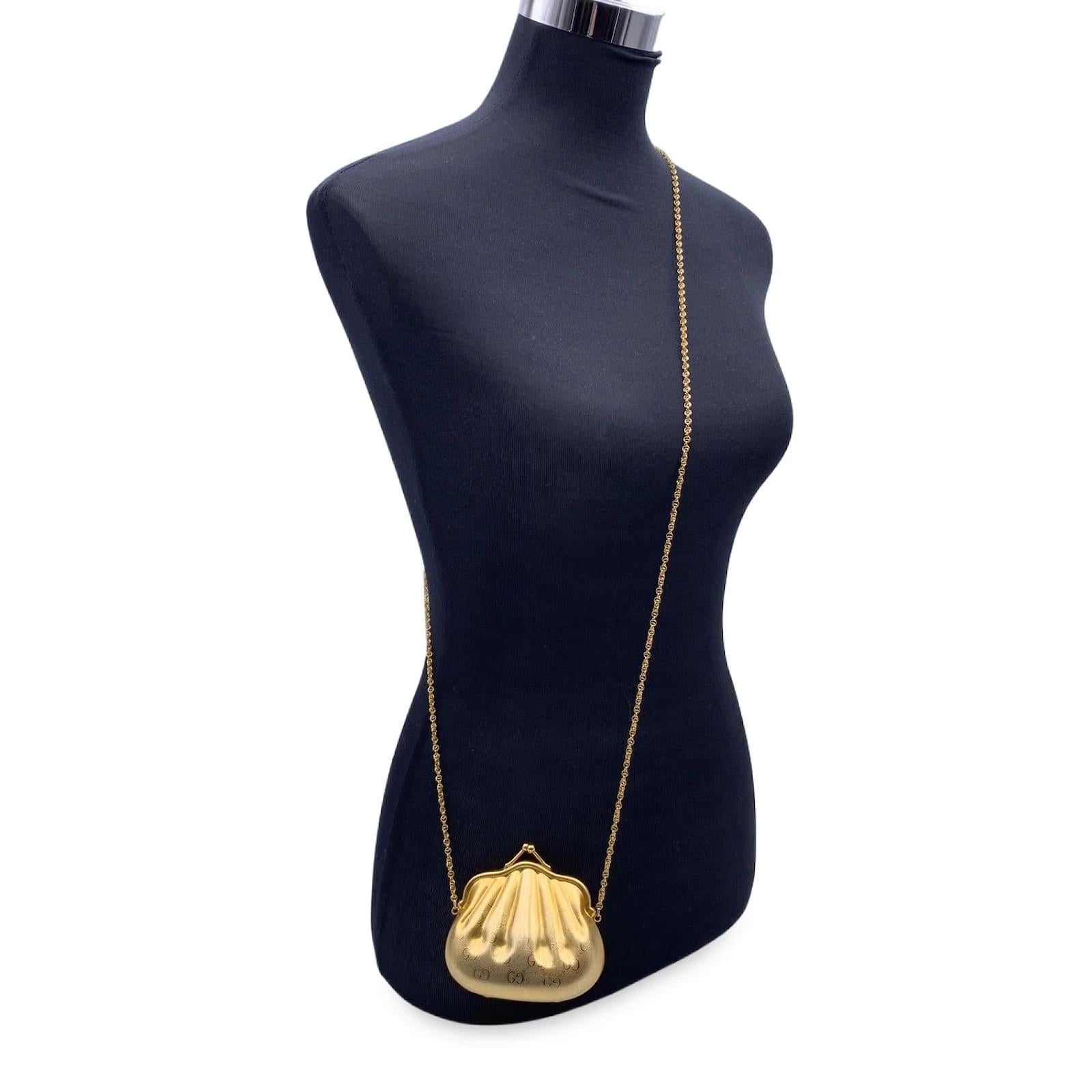 This Vintage mini coin purse is from the Gucci Accessory Collection and is from shiny gold metal with monogram GG print. Doré. Circa 1980s. Designed by Alber Elbaz.

Sculpted logo purse.
Sculpted shell shape.
Kiss lock closure.
Twisted link chain