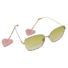 Lunettes de soleil teintées carrées en or de Gucci avec breloques en forme de cœur suspendues