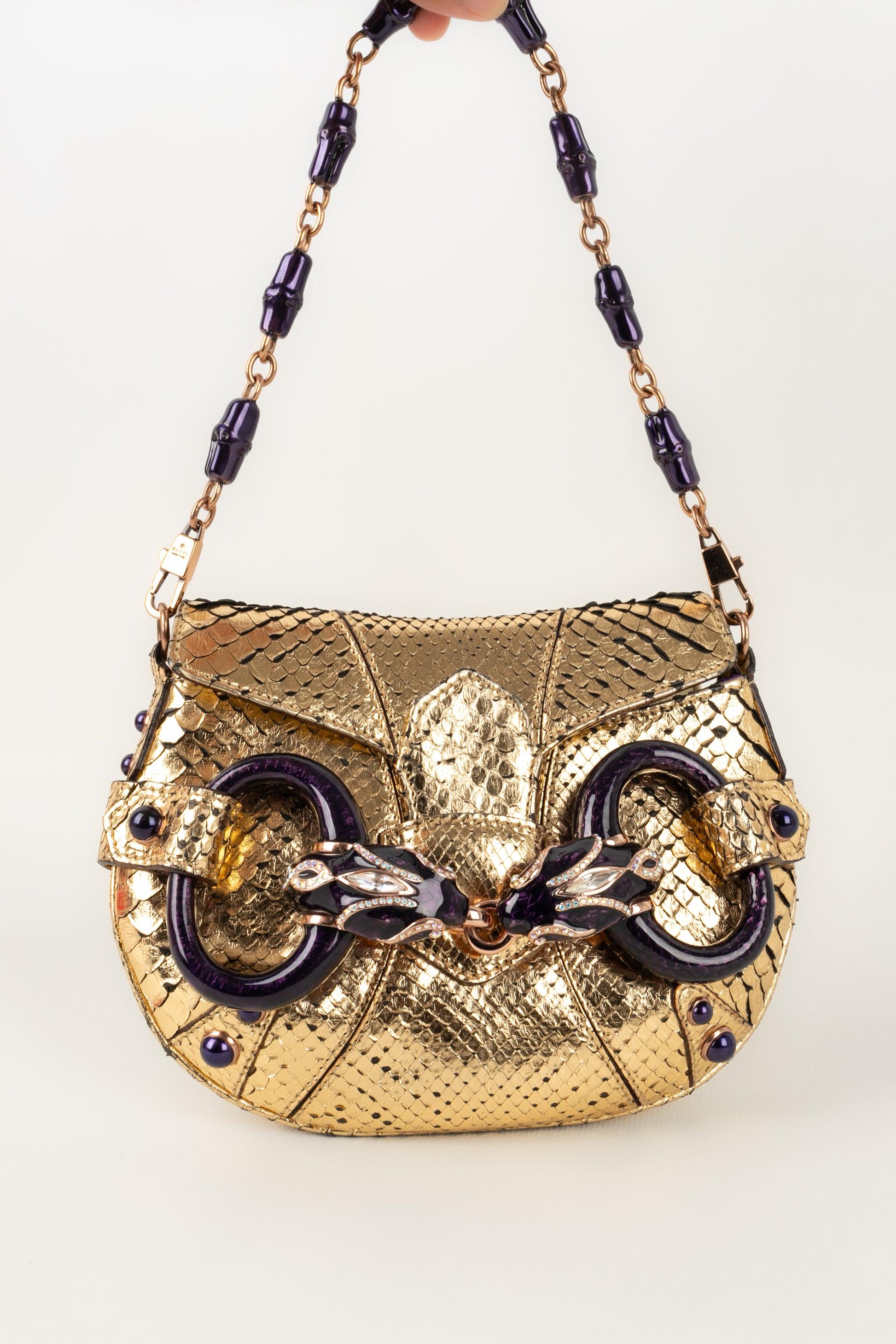Gucci - (Made in Italy) Golden exotic leather bag with enameled metal and rhinestones. Spring/Summer 2004 Collection.

Additional information:
Condition: Very good condition
Dimensions: Length: 20 cm - Height: 15 cm - Depth: 3 cm - Handle: 42