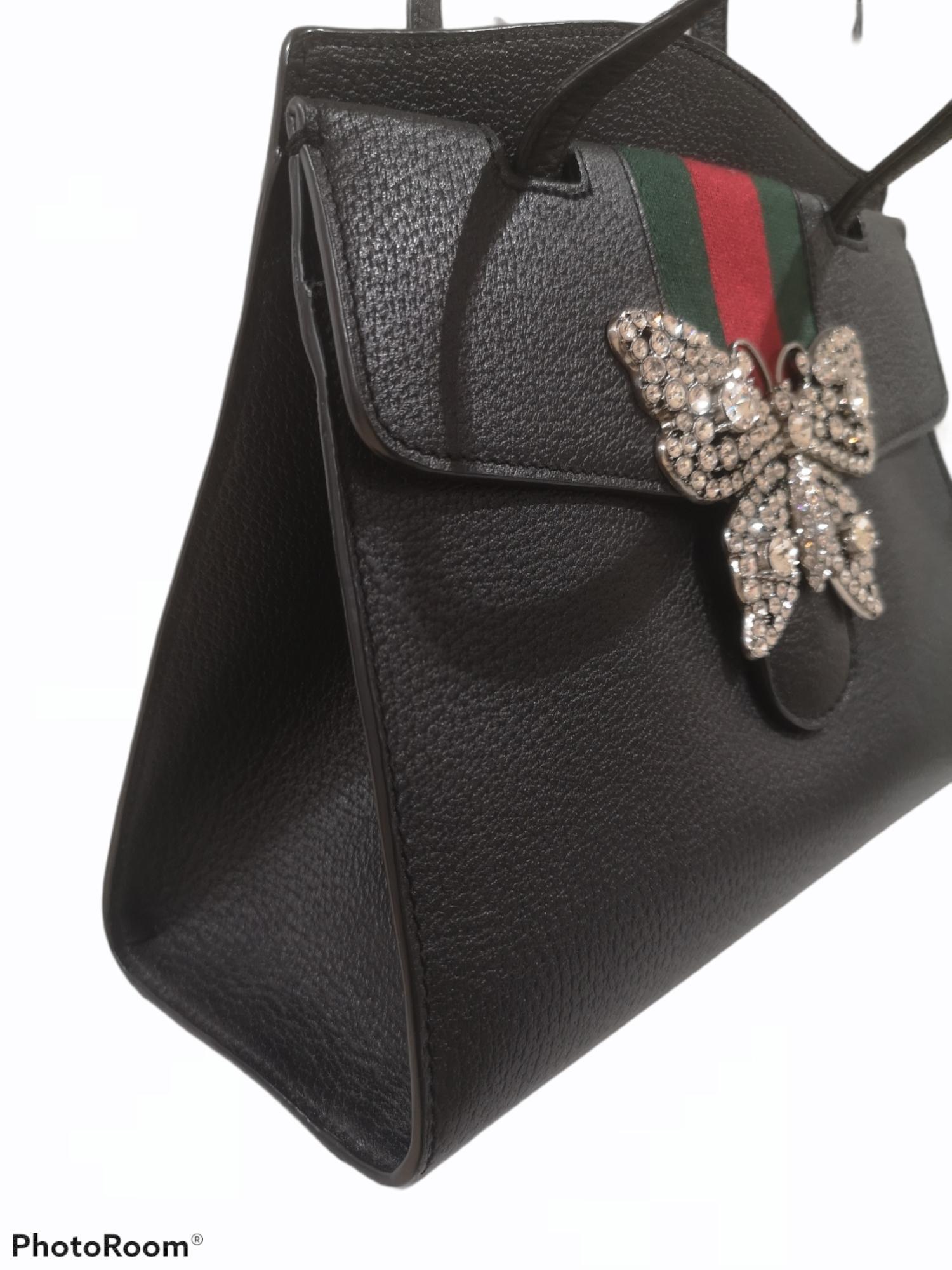 Gucci grained calfskin web butterfly handle bag
This handbag is crafted of lovely textured calfskin leather in black. This bag features a matching leather top handle with a signature Gucci web detail on the flap. The front crossover flap features a