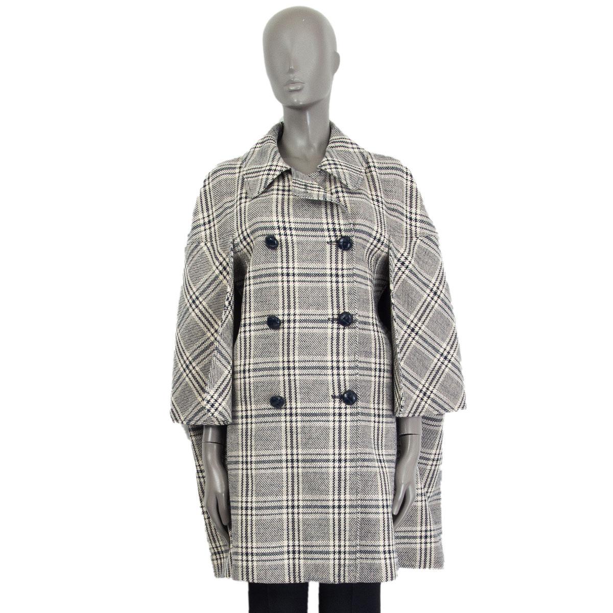 Gucci check madras cape in ivory and dark blue wool (54%), cotton (33%), linen (7%), polyamide (6%) with a flat collar, dropped shoulder silhouette and embellished with a metallic embroidered eagle patch on the back. Closes on the front with
