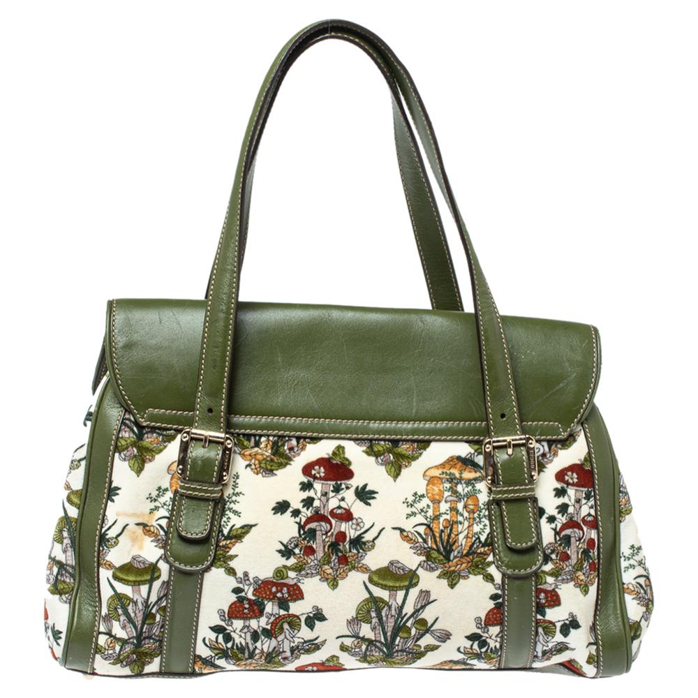 This trendsetting bag from Gucci definitely needs to be on your wishlist! It is crafted from green leather and rich floral velvet and styled with the signature interlocking G detailed front flap. It is equipped with dual top handles and opens to a