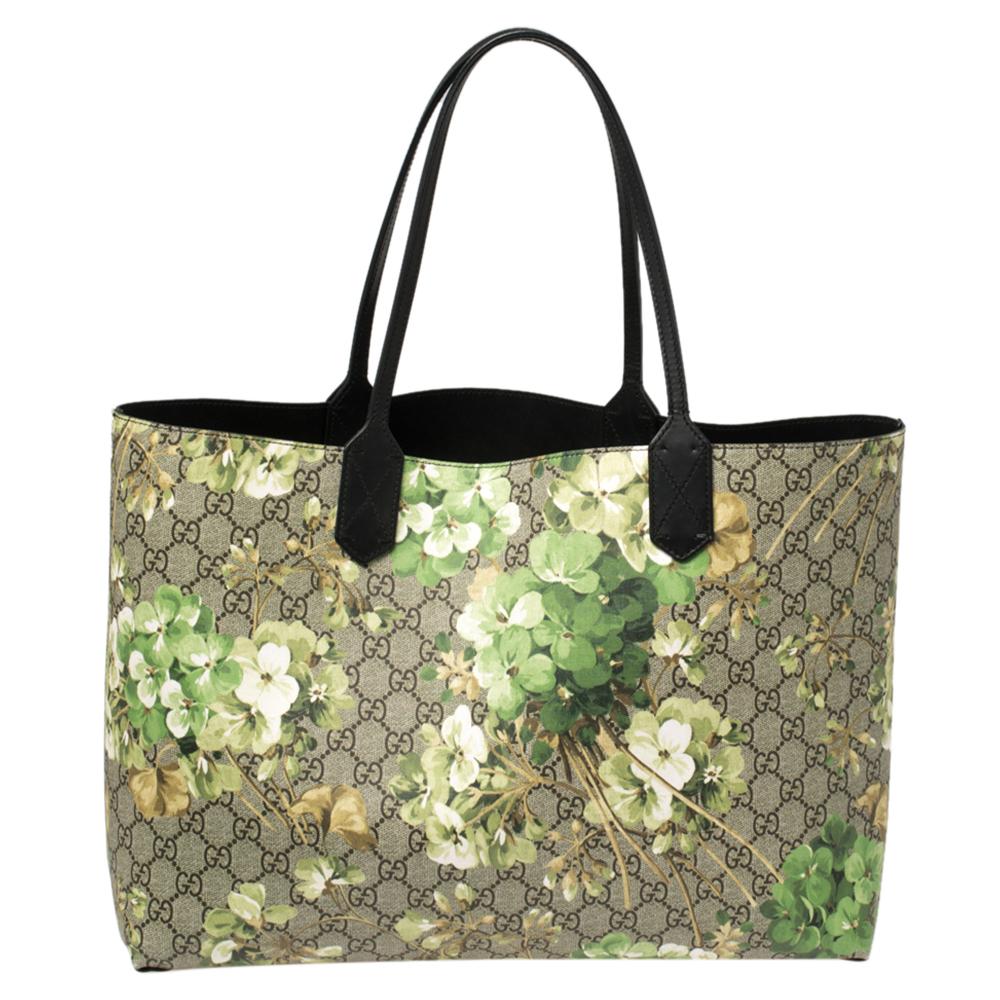 This tote handbag by Gucci is a must-have accessory that never goes out of style. Atop the GG supreme canvas exterior is the beautiful green blooms print that stands out. The reversible bag suspends from the dual handles and the spacious interior