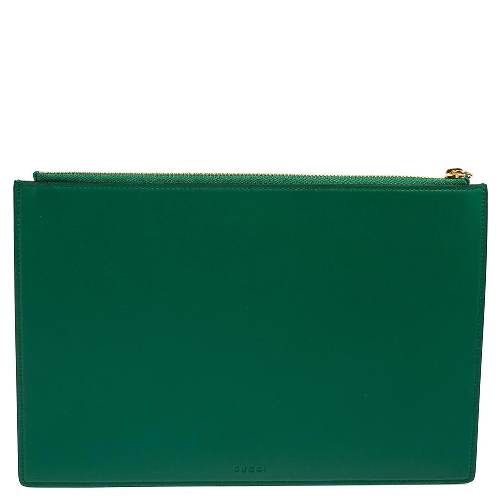 This pouch by Gucci is absolutely stunning. Crafted from leather, it comes in a lovely shade of green. It flaunts a simple silhouette and a tiger print on the front accompanied by L'Aveugle Par Amour lettering. It has a top-zip closure that leads to