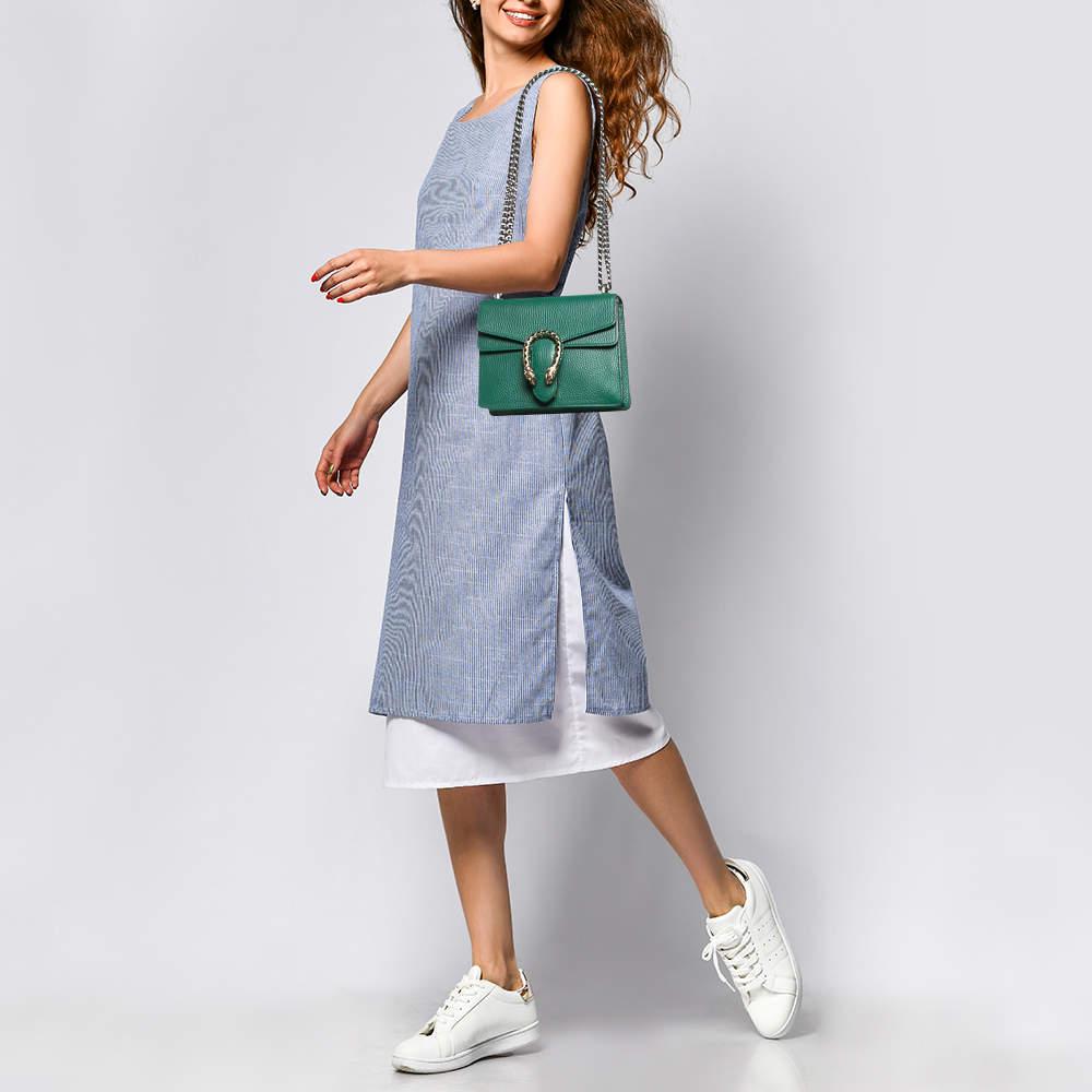 Guccis inspiration for creating such effortlessly charming and feminine collections comes from the Houses rich and varied history. This Dionysus bag from Gucci exhibits green leather  which is garnished by the signature Tiger Head closure. It is