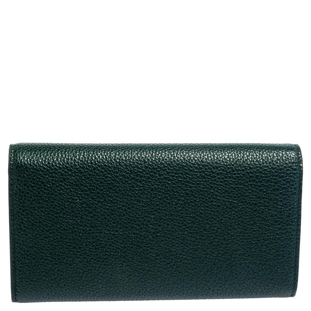 This Zumi wallet from the House of Gucci, with its multi-purposeful style and well-made shape, will prove to be your go-to accessory in no time. It has been made using green leather on the exterior with a two-toned metal motif perched on the front.