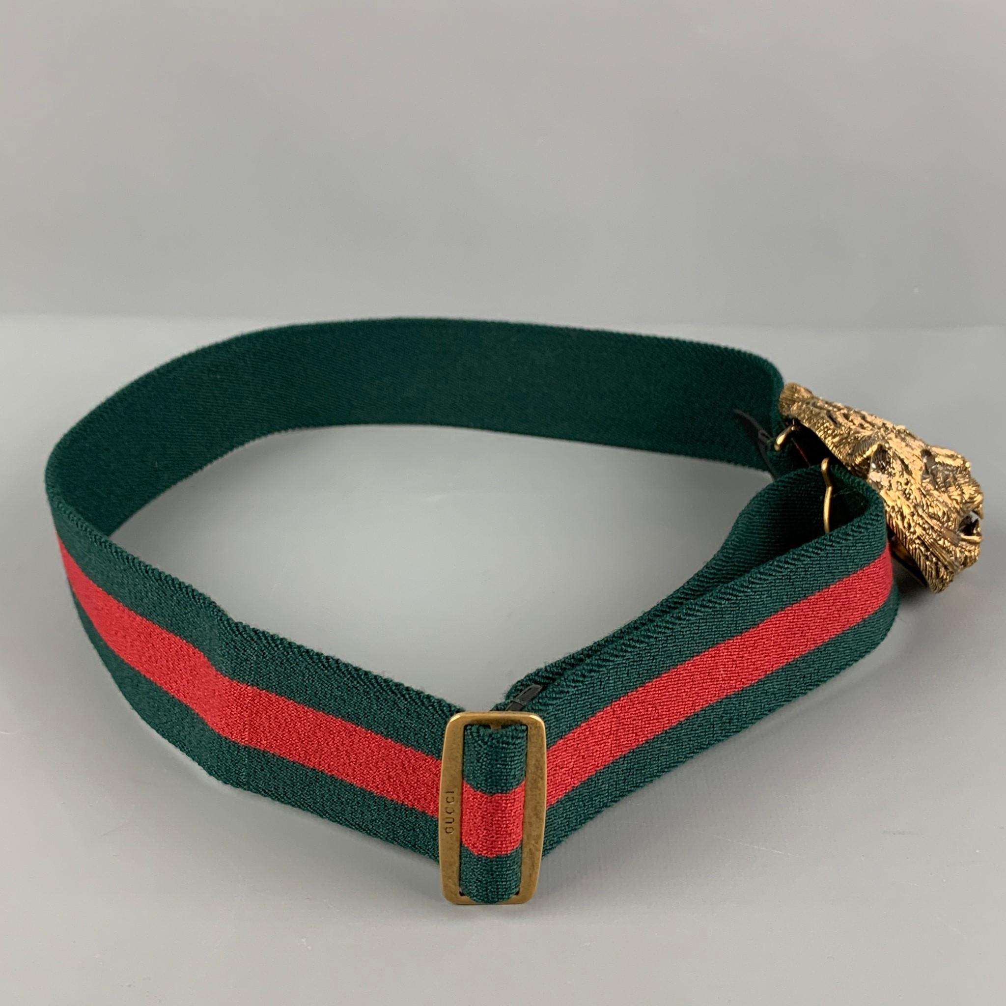 GUCCI belt comes in a green & red stripe fabric featuring a brass feline head buckle with a hook & loop closure. Made in Italy.

Very Good Pre-Owned Condition.
Marked: 446944 HGW1T / 75-30

Length: 27 in.
Width: 1.5 in.
Buckle: 3 in. 