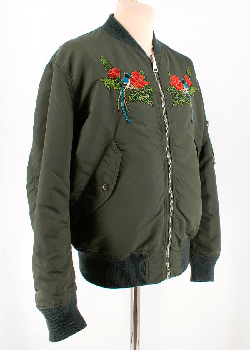 Gucci - Green reversible bomber jacket 

- floral and bird embroidery across the chest
- popper buttons on pockets - further zip pocket on left arm - zip fastening - 'blind for love' print on the back - quilted lining - ribbed wool trim 

Please