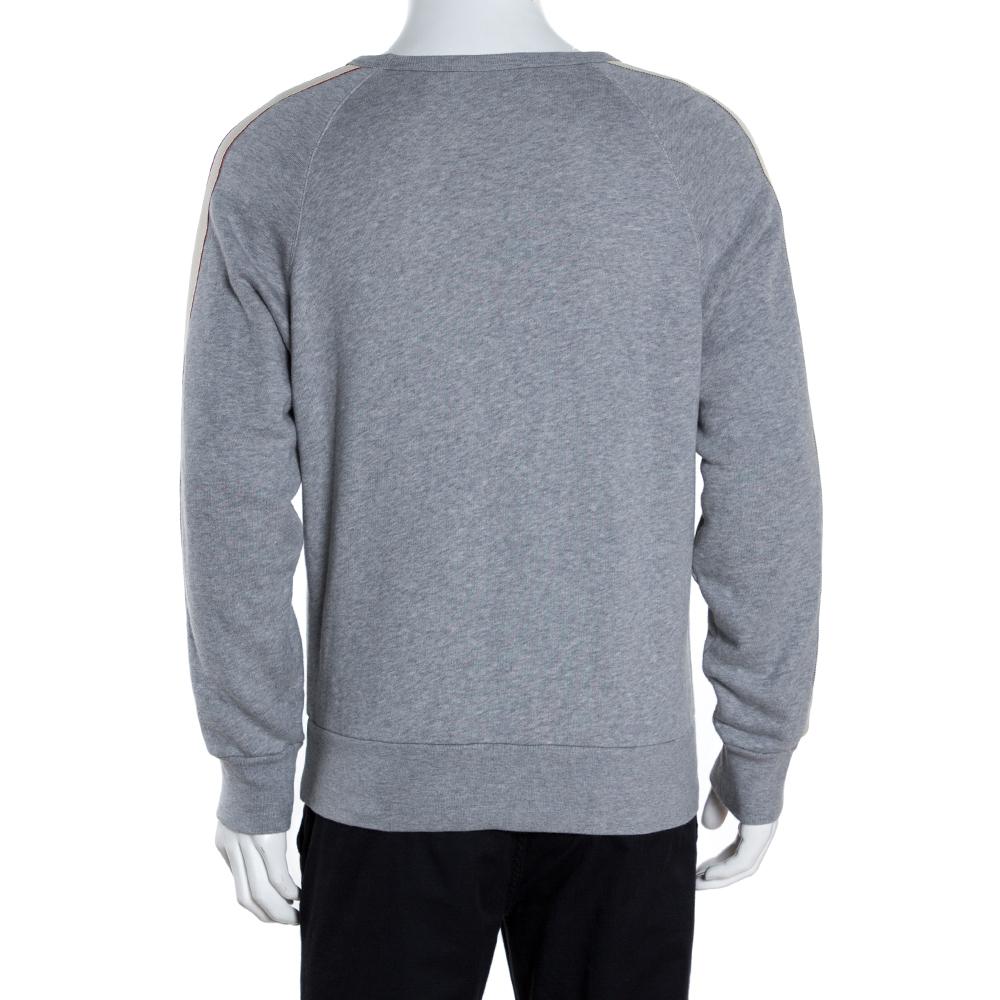 This sophisticated and stylish sweatshirt comes from the house of Gucci. Crafted from 100% cotton, it comes in a lovely shade of grey. It is styled with a round neck, logo tape detailing on the long sleeves and a good fit. It is great for outings