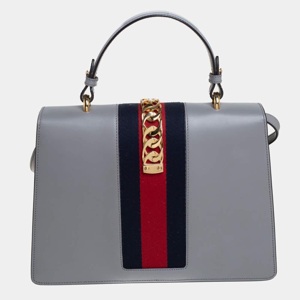 From the house of Gucci comes this gorgeous Sylvie bag that will perfectly complement all your outfits. It has been luxuriously crafted from leather and styled with floral embroidery dazzled sequins on the front, chain-web decorated flap, and a