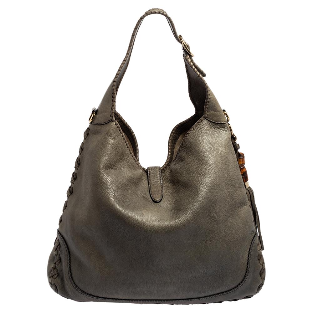 The New Jackie hobo from Gucci is a sensational creation that is highly admired and popular. It is created using grey leather on the exterior and features a lock closure on the front, gold-toned hardware, and tassel motifs. It is characterized by