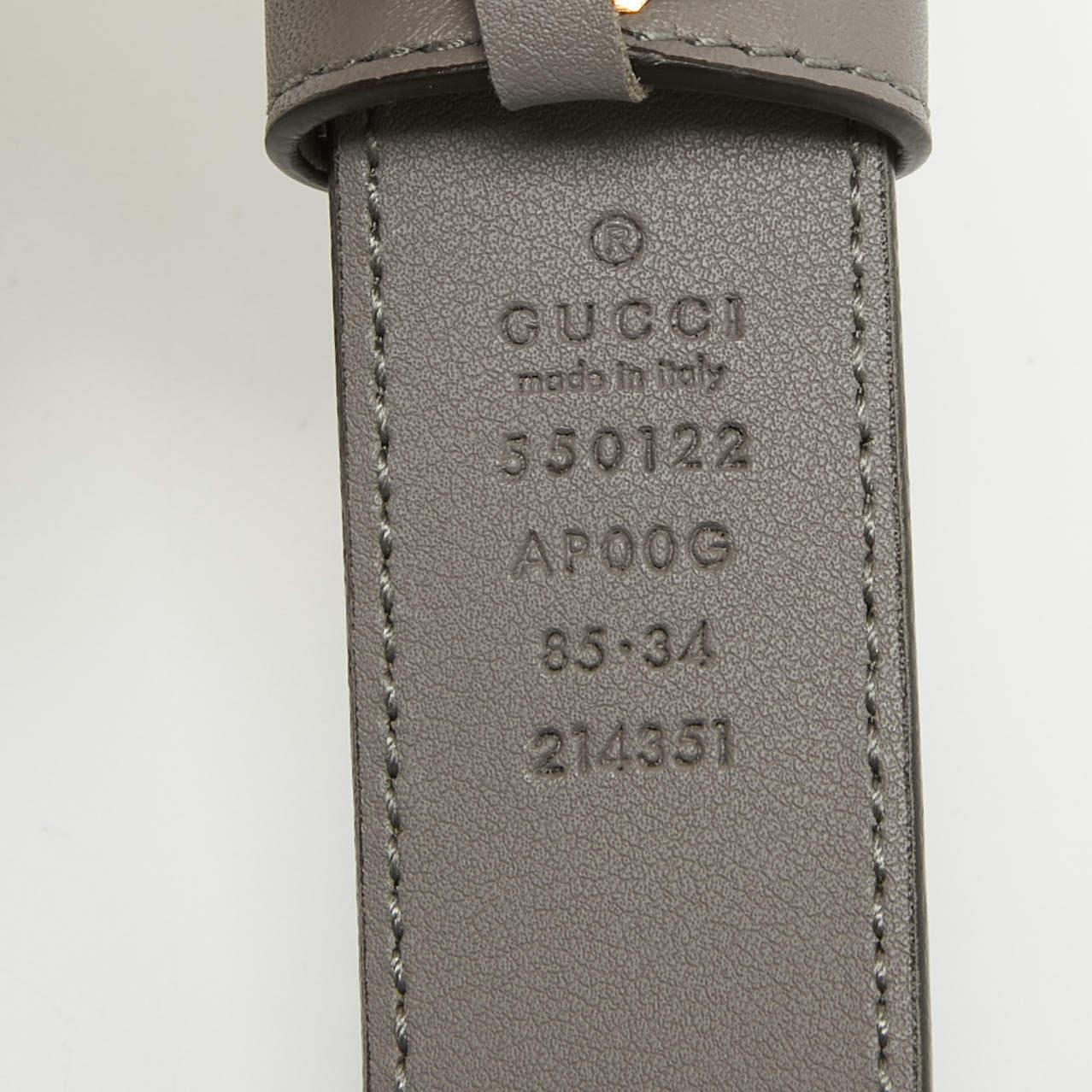 Dieser Gürtel von Gucci vereint zwei der einzigartigsten Codes des Labels in sich. Die Kreation ist aus feinem Leder in einem grauen Farbton gefertigt und mit der charakteristischen Zumi-Schnalle aus goldfarbenem Metall versehen. Nehmen Sie diesen