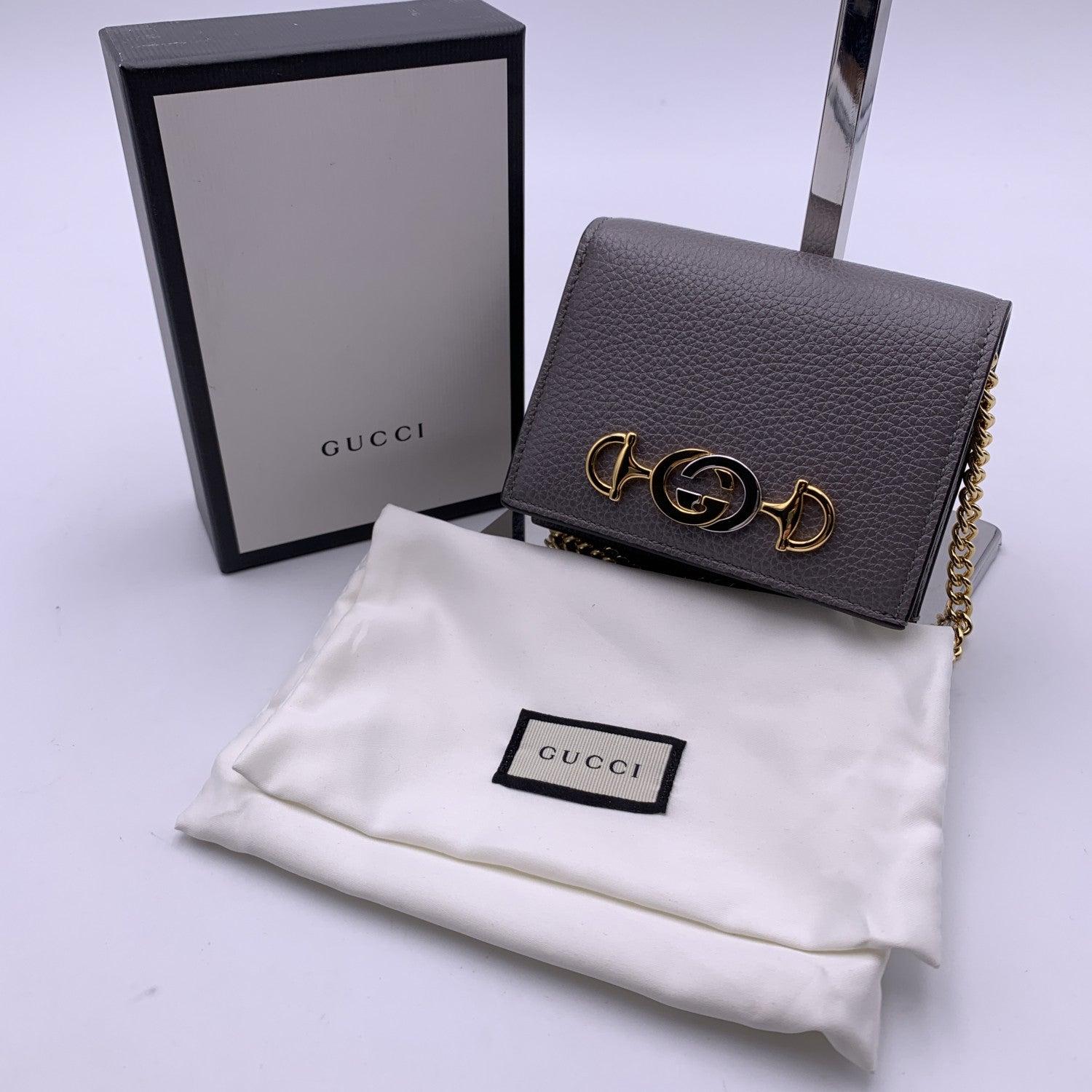 Beautiful Gucci 'Zumi' credit card holder wallet with chain, crafted in grey leather with gold and silver metal GG logo and horsebit detailing on the front. Gold metal removable chain. Leather and fabric interior. Inside it has: 6 credit card slots,