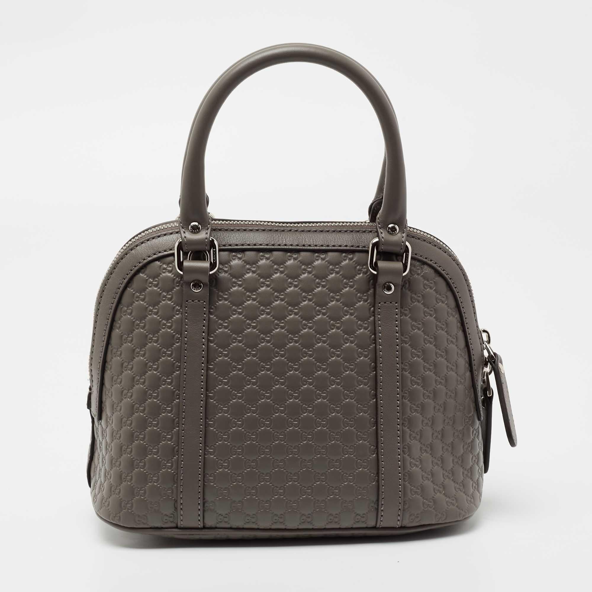 This mini Dome bag from the house of Gucci is an absolutely beautiful creation. Crafted using grey Microguccissima leather, this bag features gold-toned hardware along with top dual handles and a shoulder strap. The zipper leads us to the spacious