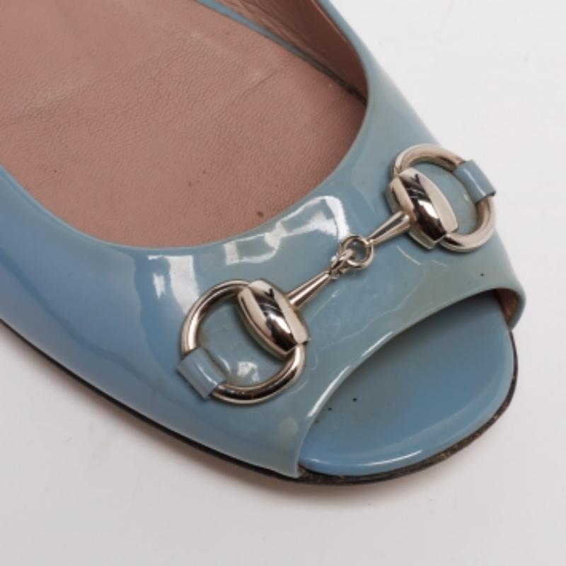 Add a dash of chic to your closet this season with these Gucci ballet flats. Designed in grey patent leather, this pair comes with a rounded peep-toe with the signature Horsebit detailing at the vamps. Slightly cushioned insoles and durable soles