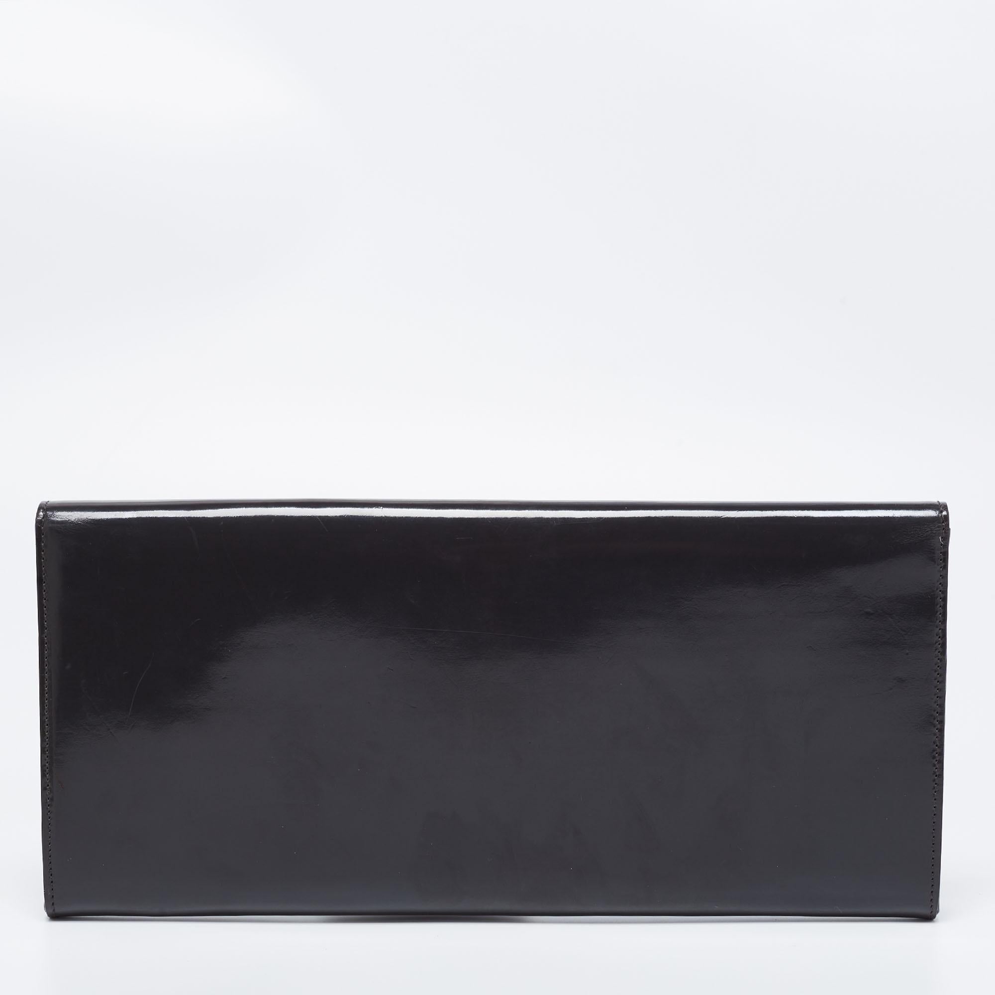 This sleek Sigrid clutch from Gucci is a masterpiece. Crafted in Italy, it is made of patent leather and comes in a beautiful shade of grey. It flaunts a front flap that features delicate silver-tone cutout detailing and the brand logo. The bag
