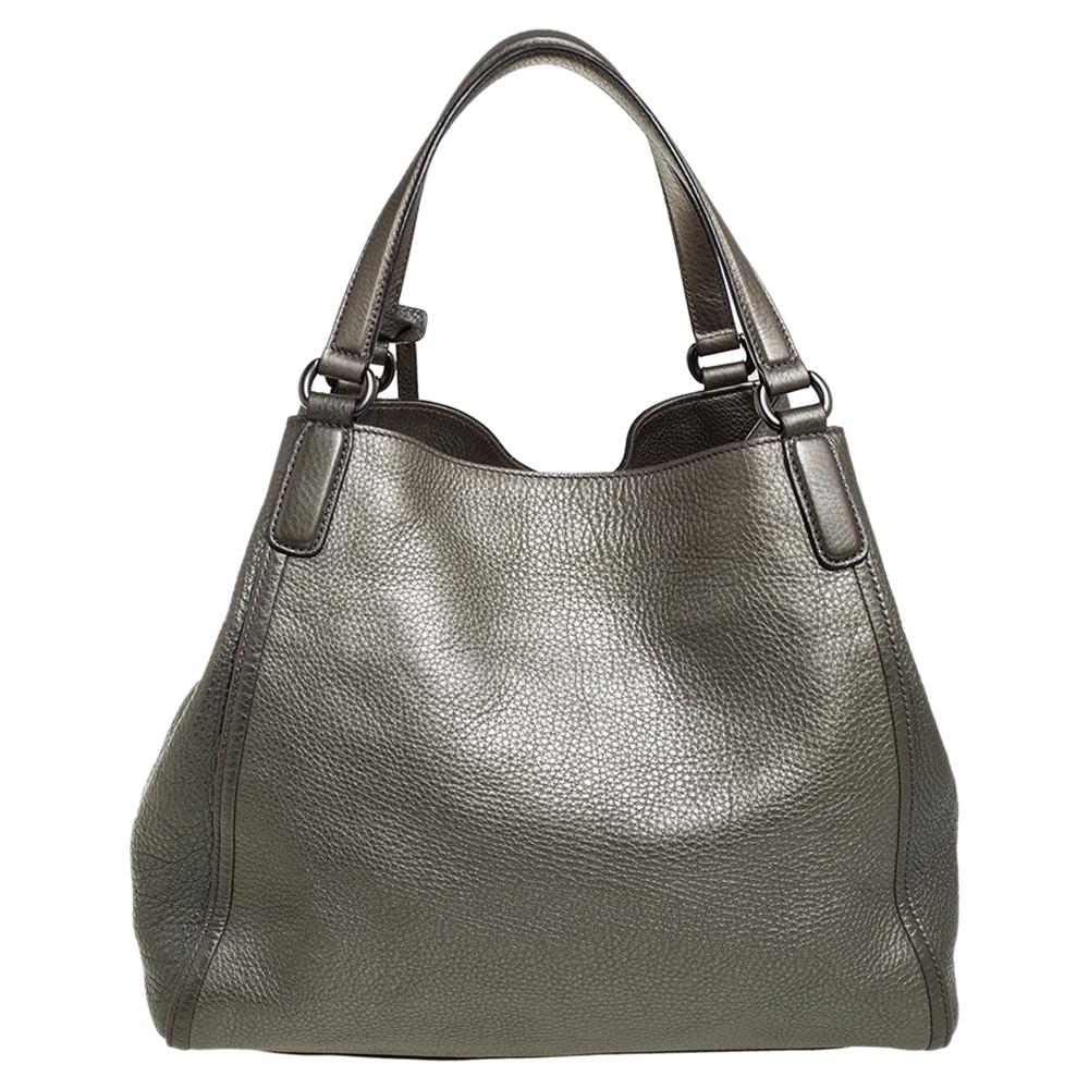 This Soho bag is one of the many loved designs by Gucci. The bag is constructed from pebbled leather and designed with the signature GG on the front. It features a canvas interior for your essentials, two top handles and a tassel charm. It is sure