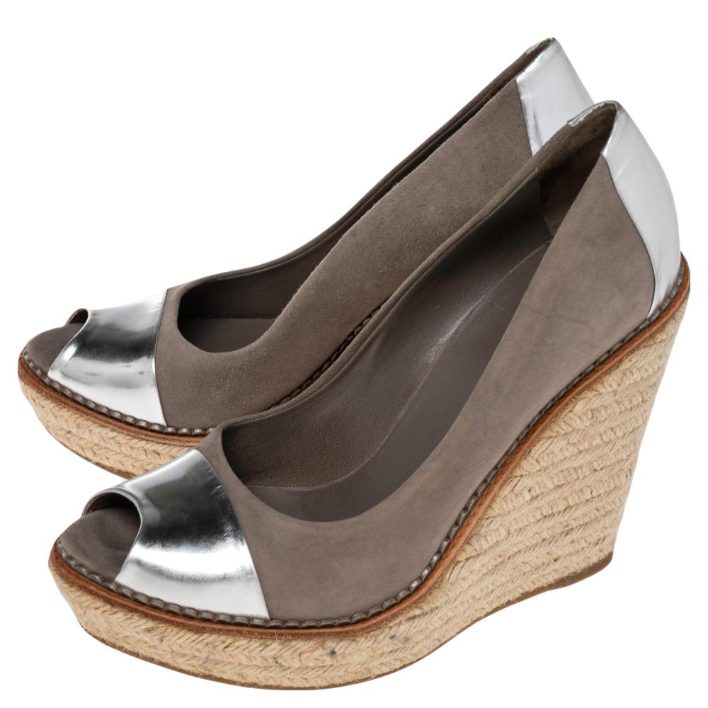 These Gucci peep-toe wedges are sculpted with suede with metallic silver leather panels on the front and at the counter. Elevated at 13 cm of height, these espadrilles wedges are well accentuated with a combination of color, style, and