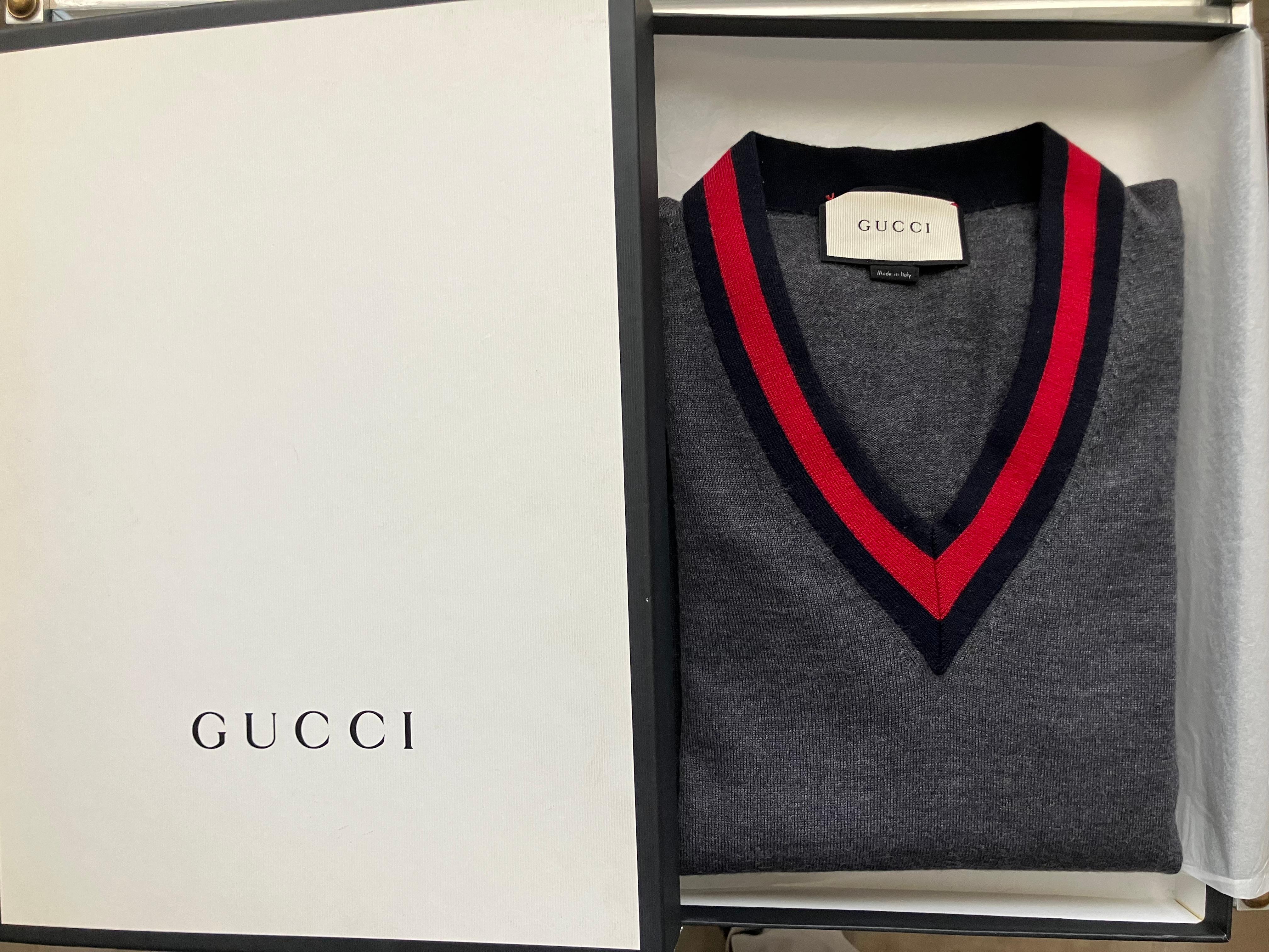Gucci Pullover mit V-Ausschnitt aus grauer Wolle. Pullover aus grauer italienischer Wolle mit V-Ausschnitt und klassisch blau-rotem Gucci-Streifen. Medium. Das perfekte Geschenk zum Vatertag. Italien, 2015

Abmessungen. Größe Medium
