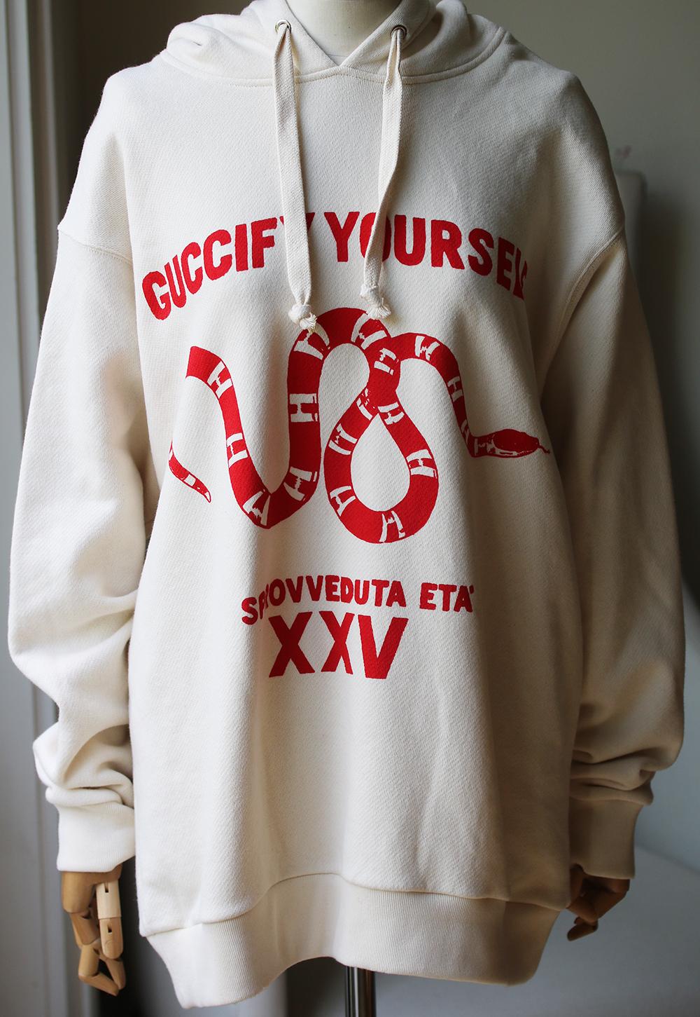 An ivory sweatshirt with a red print. The print includes the phrase 