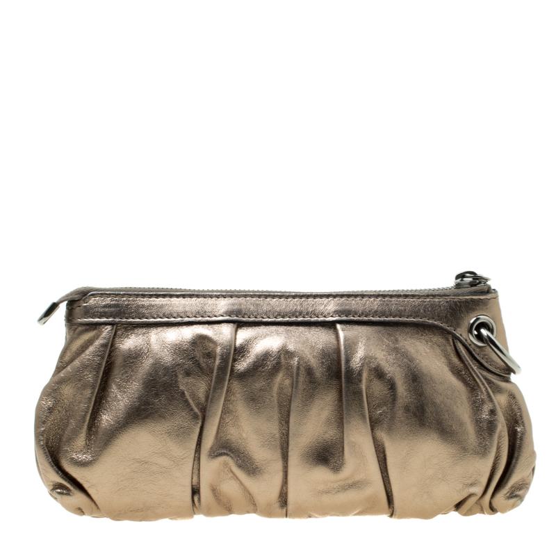 Have all eyes on you when you flaunt this stunner of a clutch by Gucci. Crafted from leather, it carries a metallic shade and a zipper which secures the leather interior for your essentials. Tassels with bamboo touches make the clutch