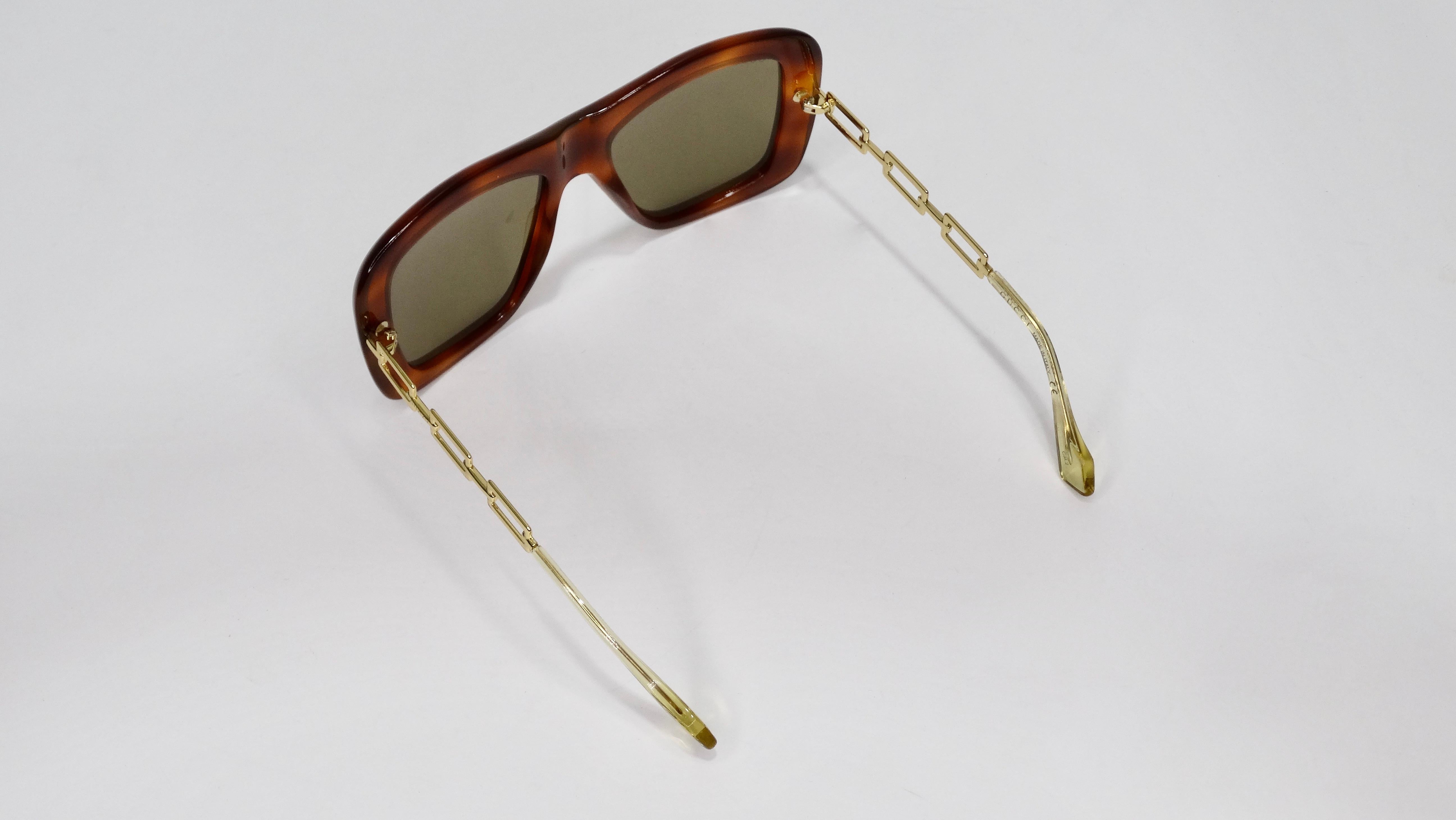 Snag yourself these Gucci sunnies! Circa recent 2000s but with a 1970s look, these Havana sunglasses feature an oversized frame with gold toned chain link arms. Comes with original case. Perfect to pair with your favorite Gucci monogram look or