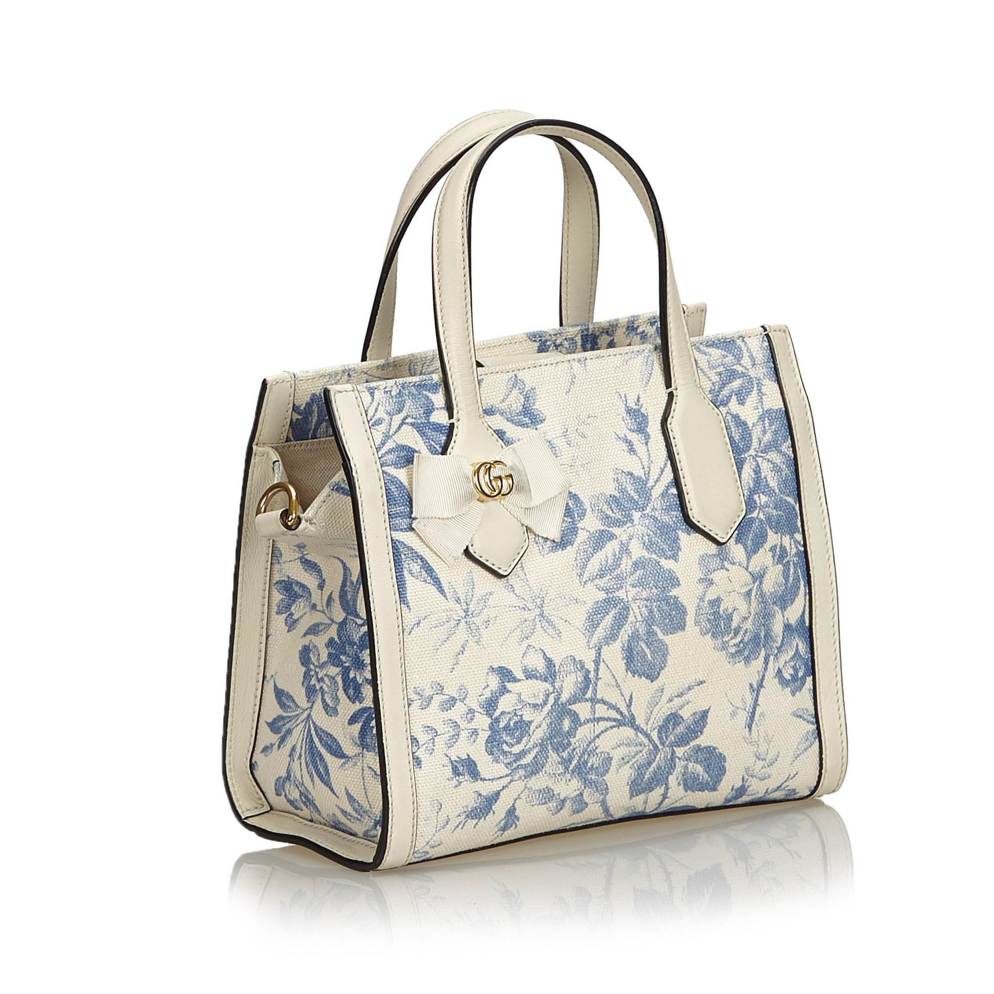 Gucci Herbarium Canvas Tote Bag

This satchel features a floral canvas body with leather trim, flat leather handles, a flat shoulder strap, an open top with a magnetic closure, and interior slip pockets. 

Approx. 

Length: 20 cm. 
Width: 23.5 cm.