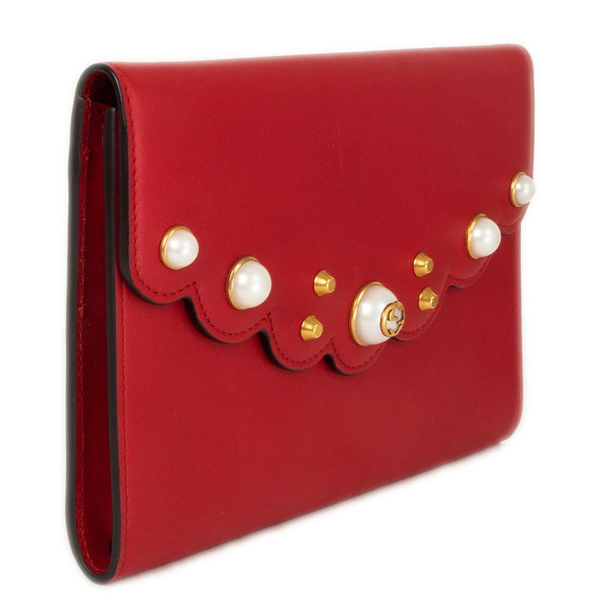 100% authentic Gucci Peony clutch in red calfskin with scalloped edges and pearl embellished flap. Lined in brown nylon with six card slots and one big zipper pocket. Brand new. Has some faint but noticable scratch at the flap. Comesw ith dust bag.