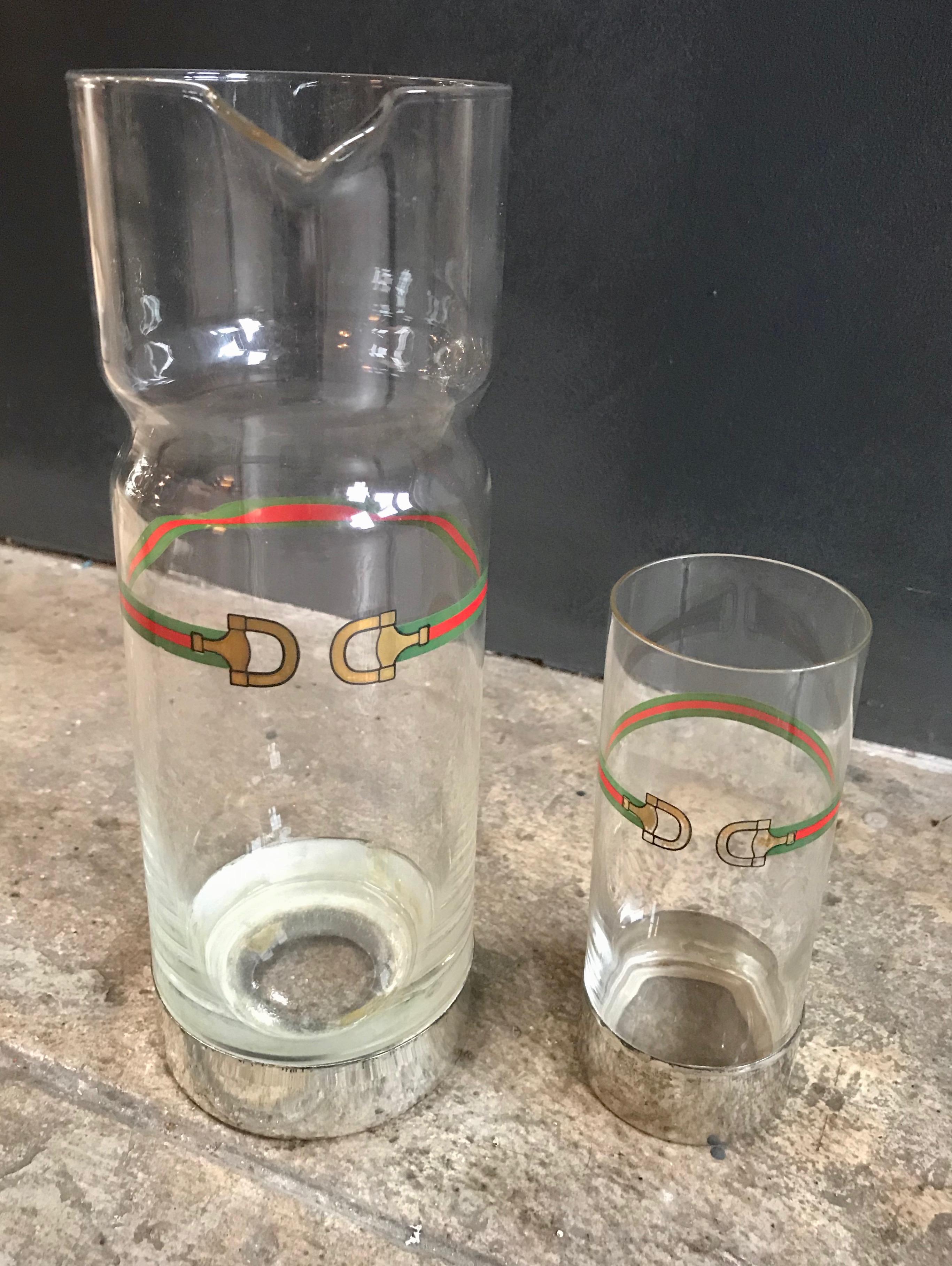 Entertain in style with this vintage barware set from Gucci, likely made in the 1970s. This fabulous set includes a tall glass decanter or pitcher and one matching cocktail glass with silver base, all of which feature Gucci's signature webbing and